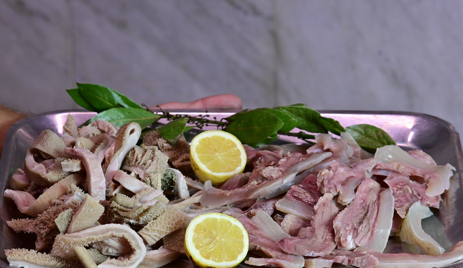 A person holding a plate of food with meat and vegetables