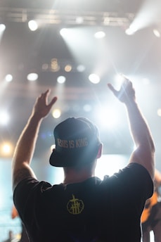 A man standing in front of a crowd holding his hands up