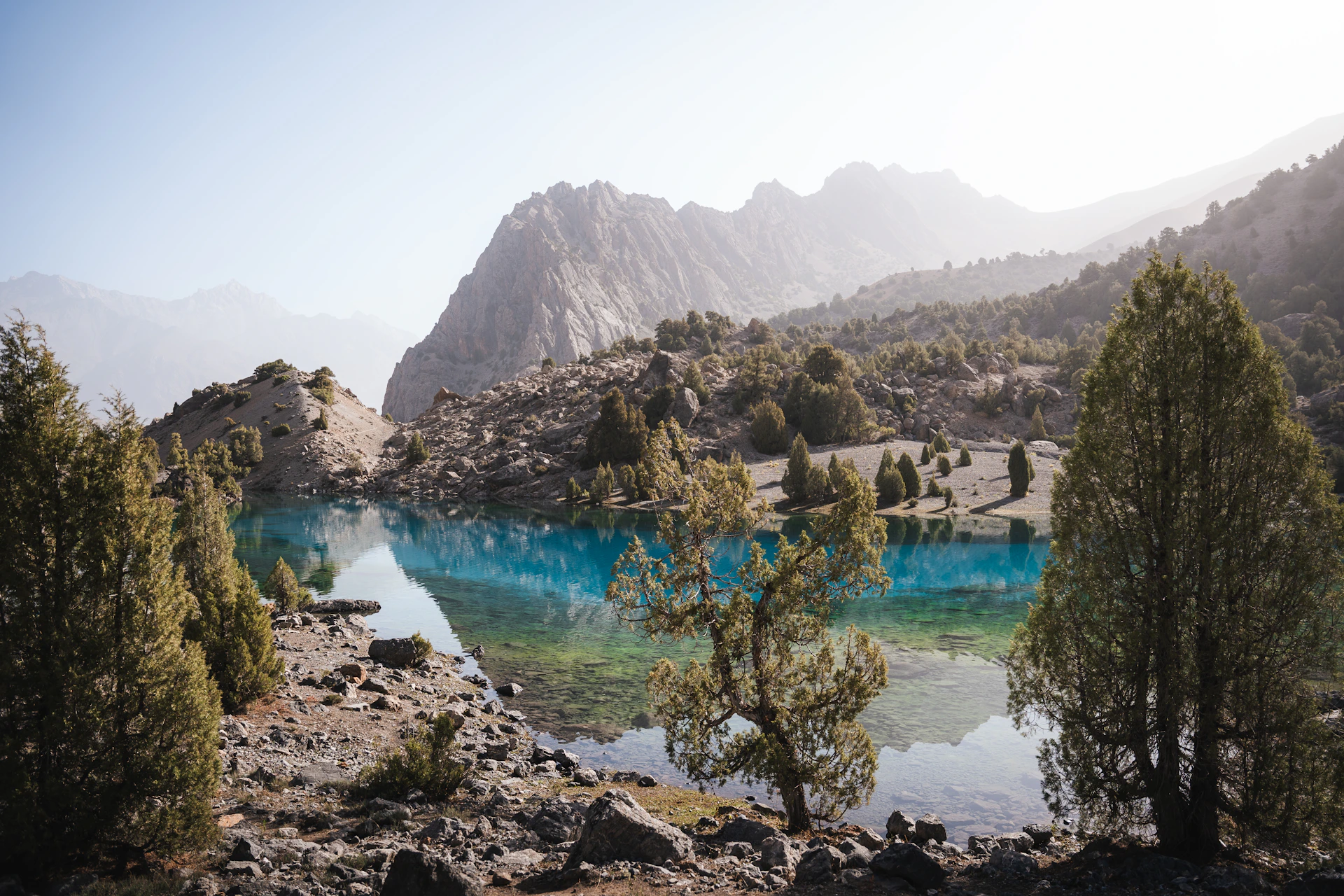 A small lake surrounded by mountains and trees