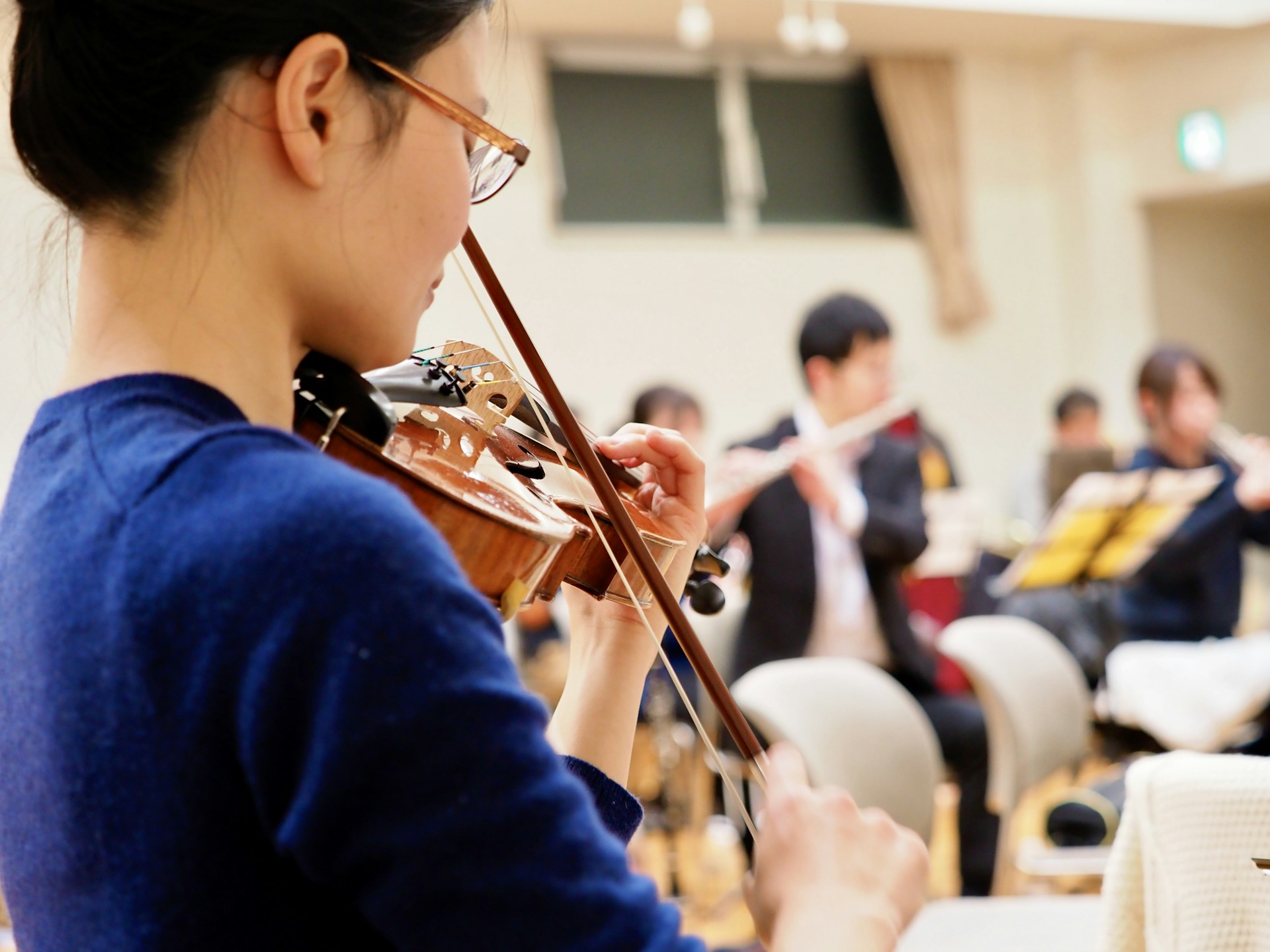 A woman playing a violin in front of a group of people