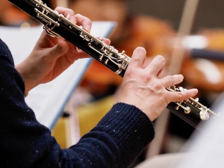 A woman holding an oboe in her hands