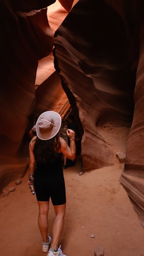 A woman standing in a slot in a canyon