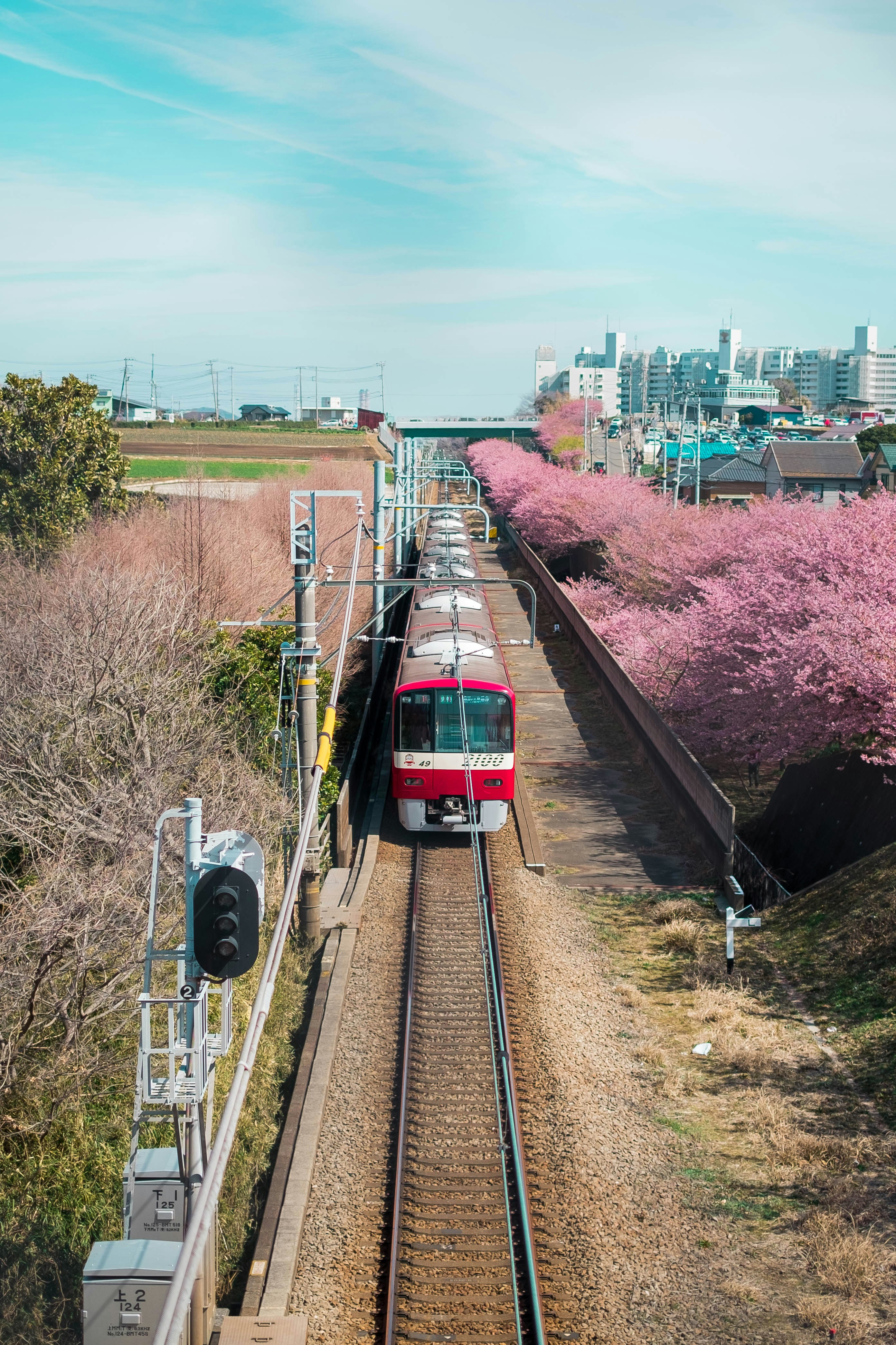 A red and white train traveling down train tracks