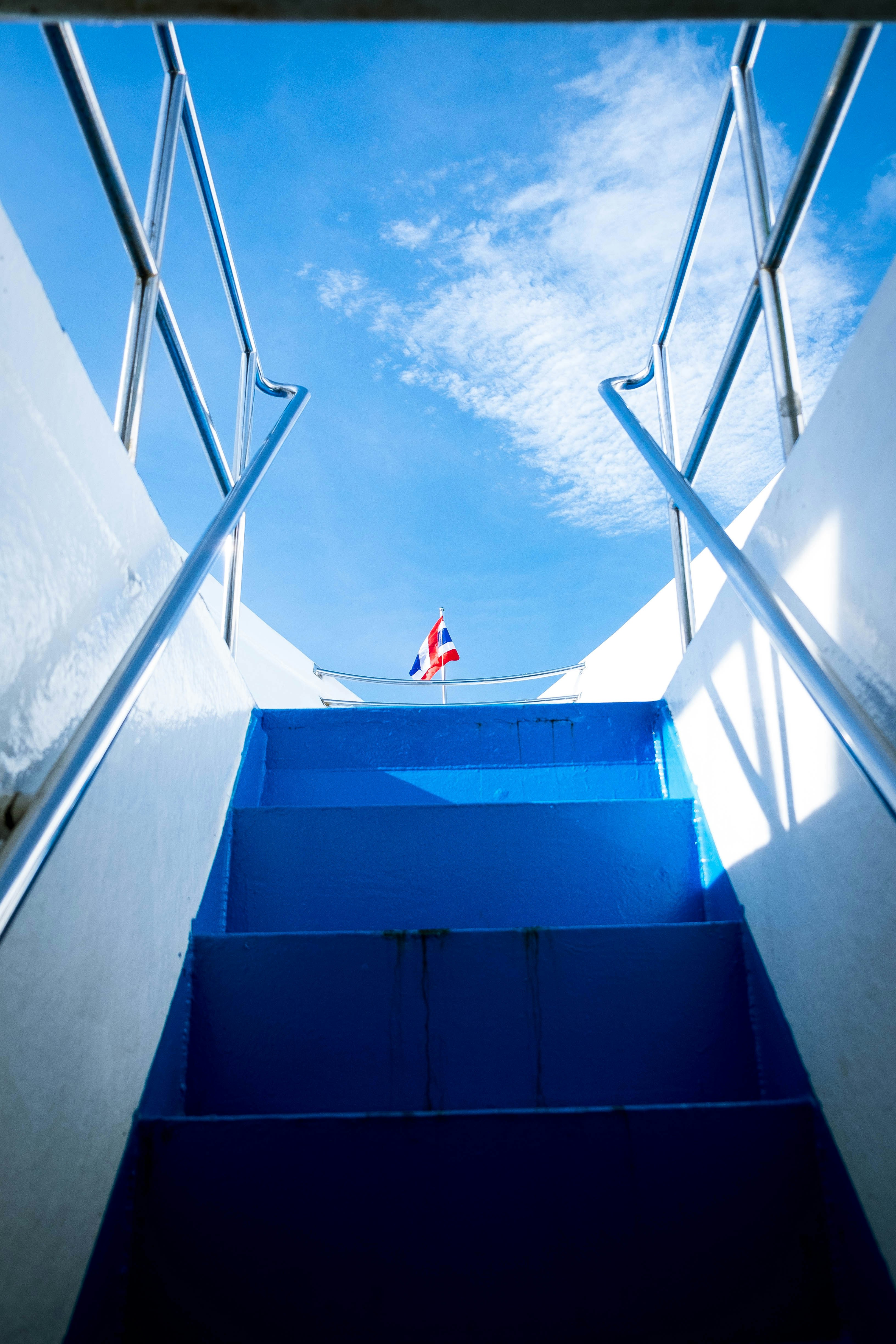 A blue staircase going up into a blue sky