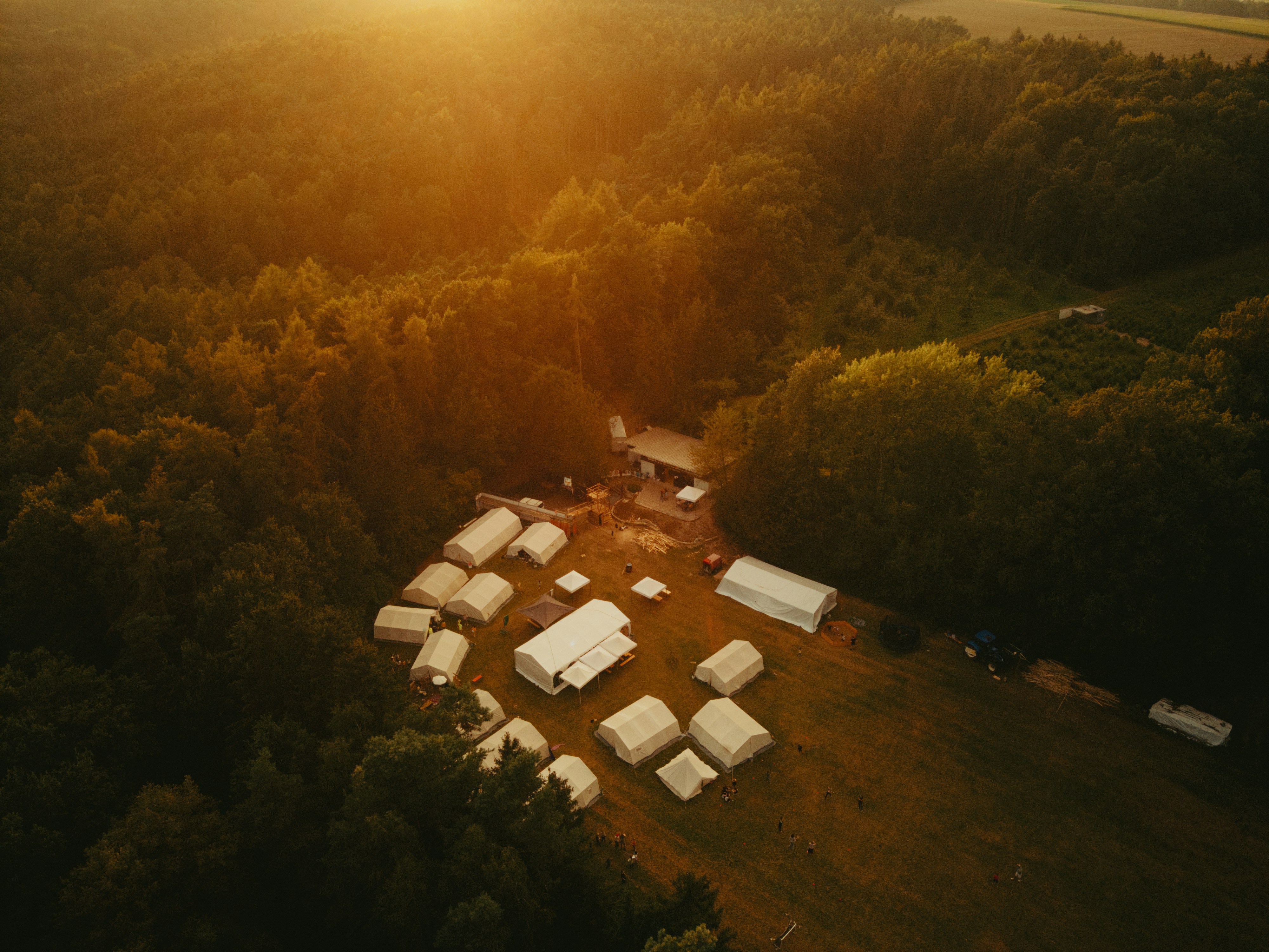 An aerial view of a farm with a sunset in the background