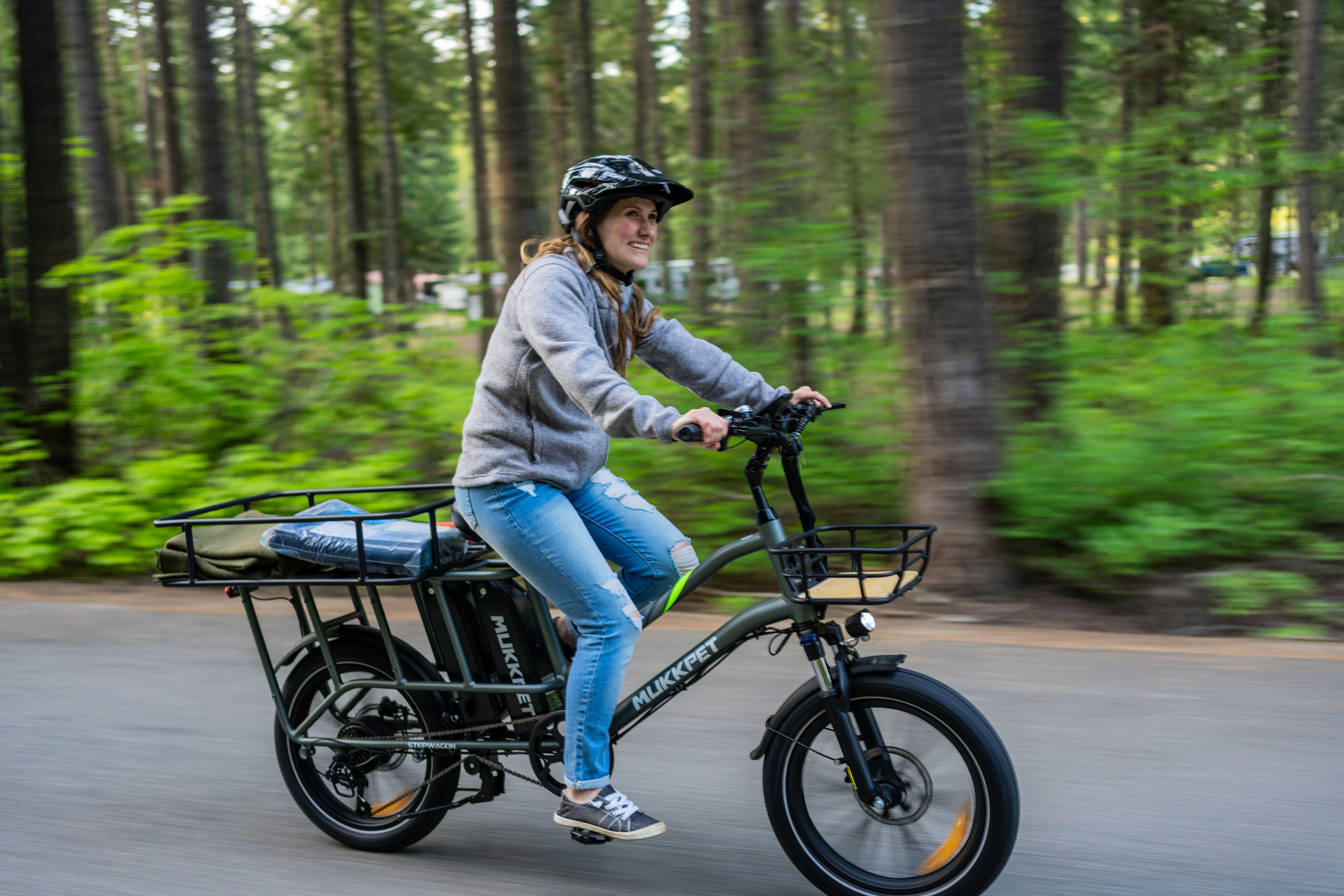 A woman riding a bike in the middle of a forest