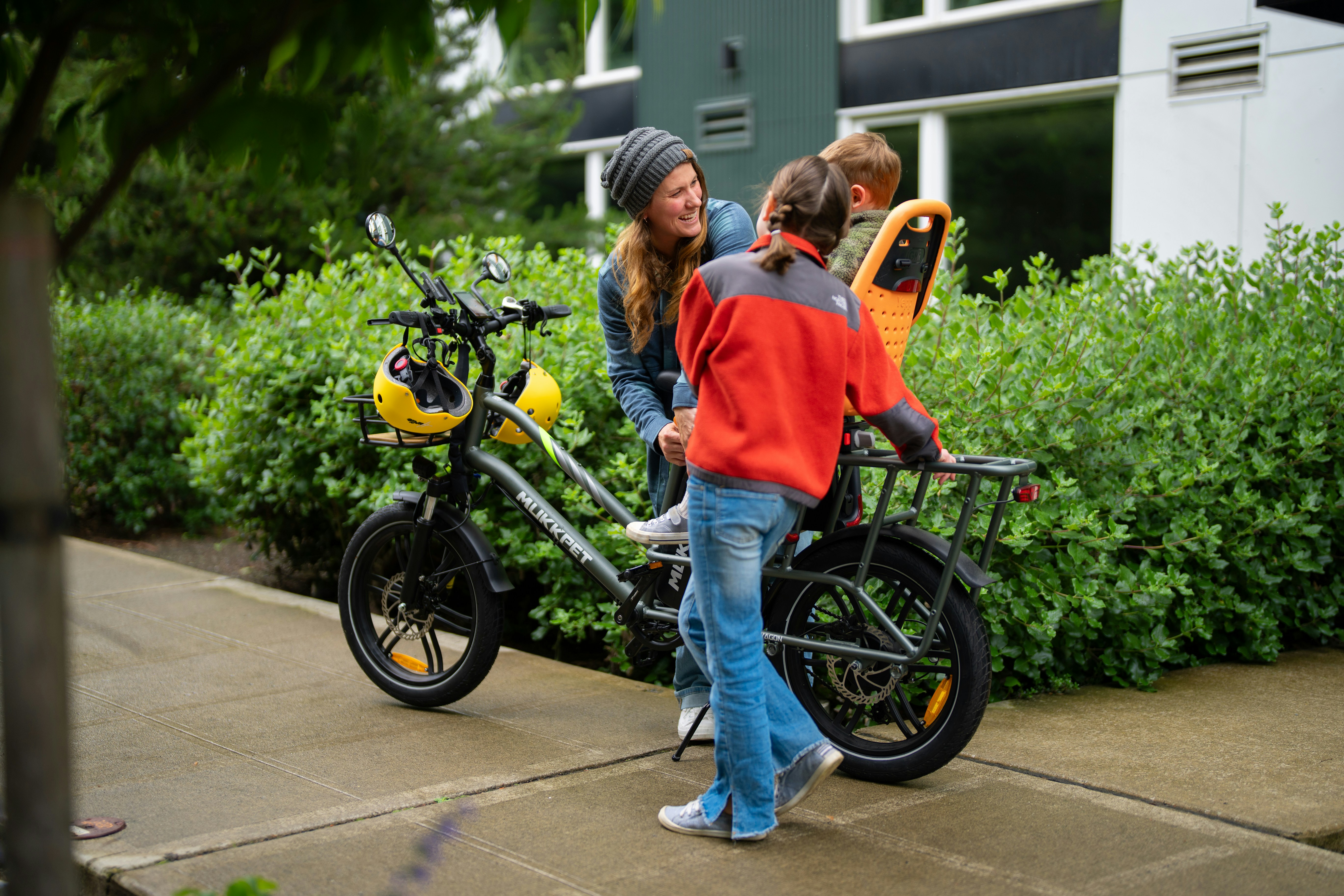A couple of kids standing next to a bike
