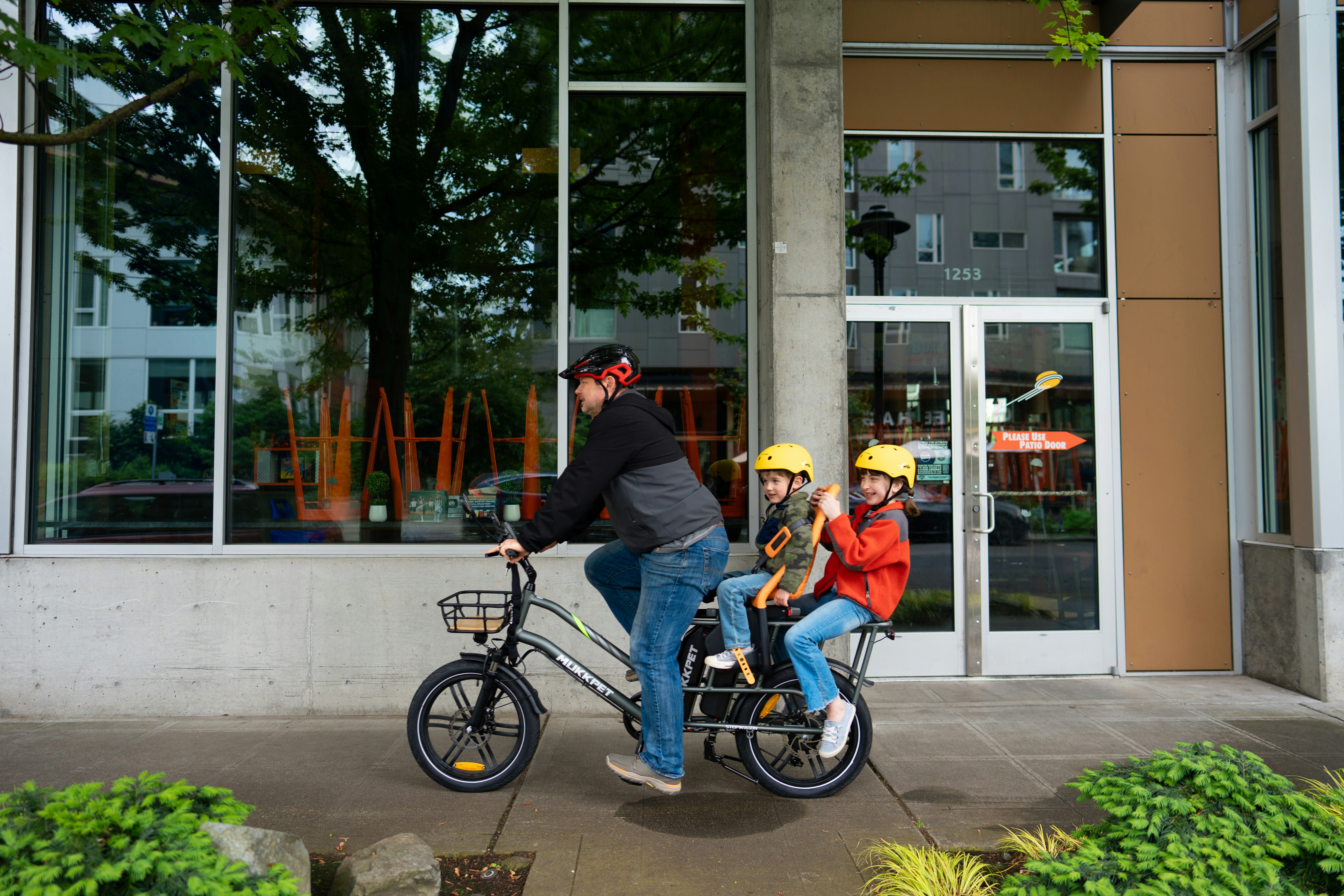 A man riding a bike next to a woman on a sidewalk