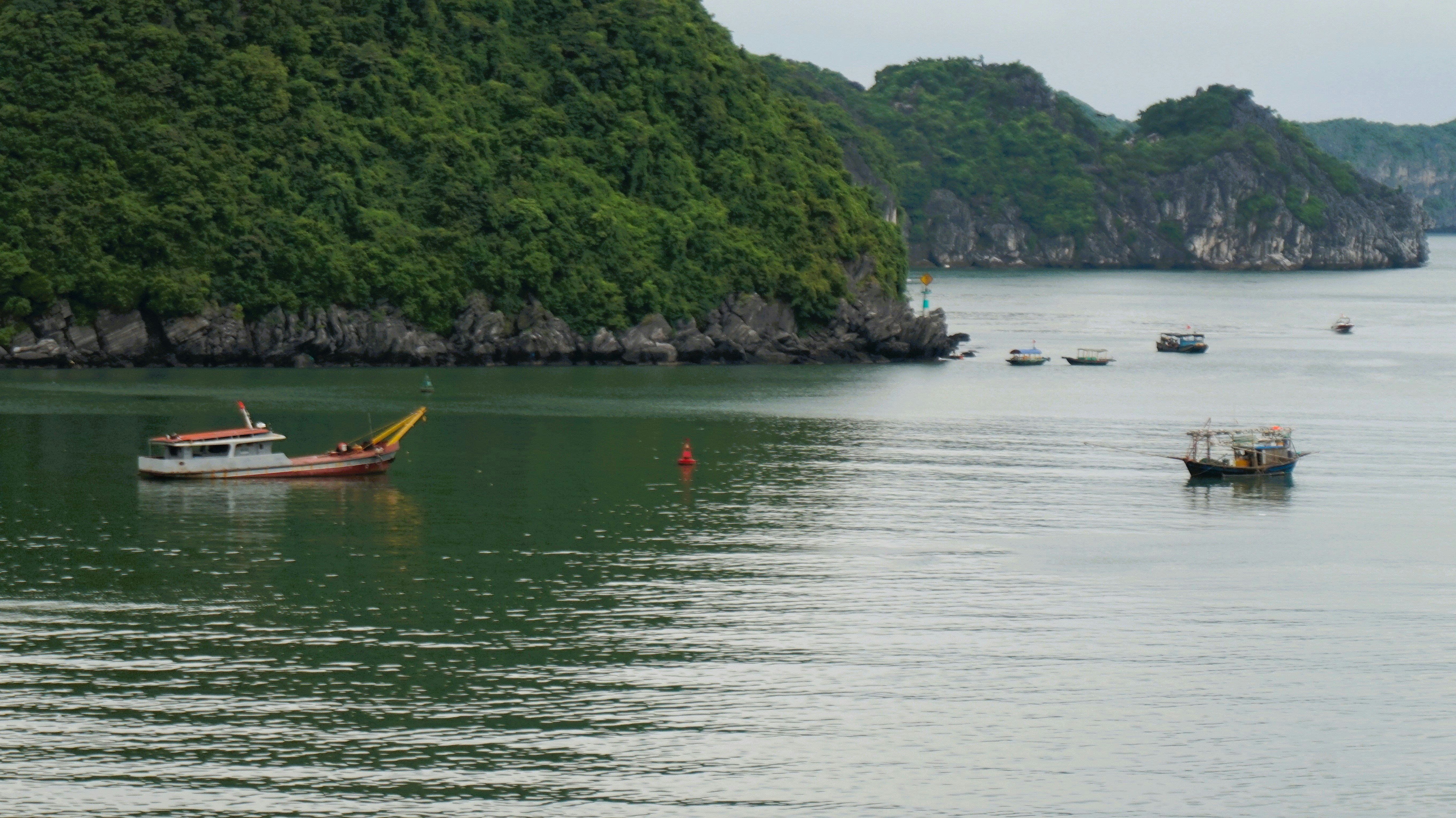 A group of boats floating on top of a large body of water