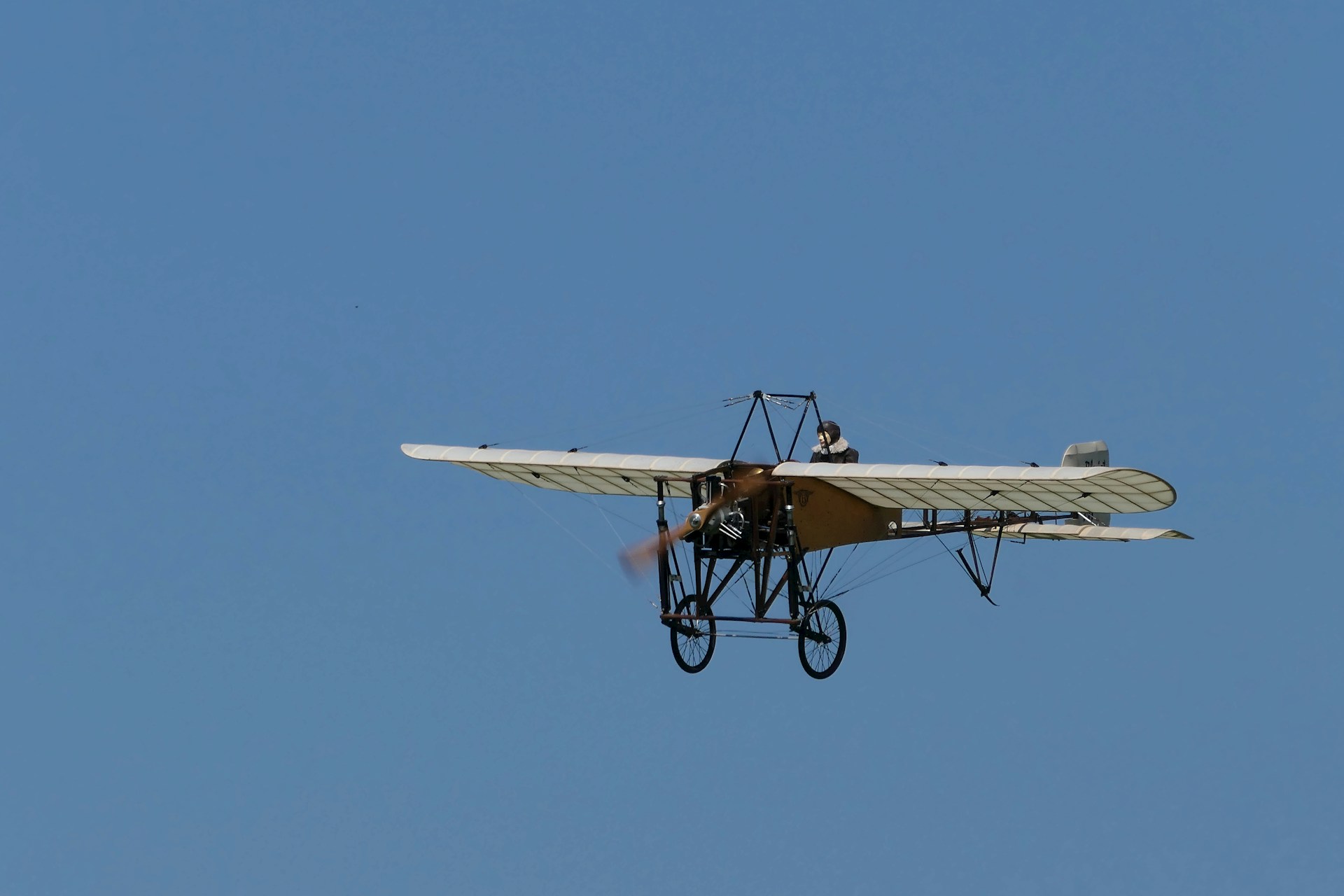 A small airplane flying through a blue sky