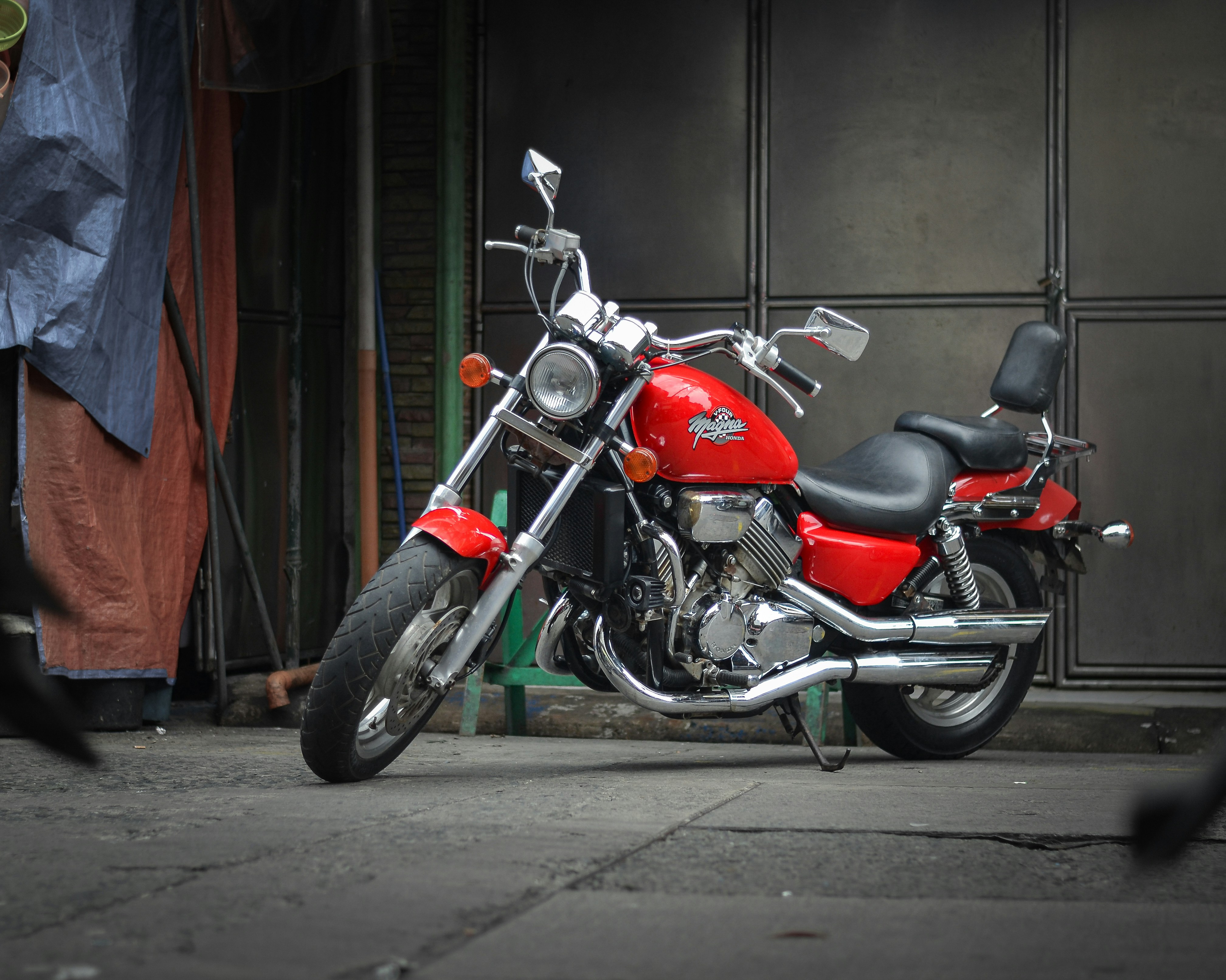 A red motorcycle parked in front of a building