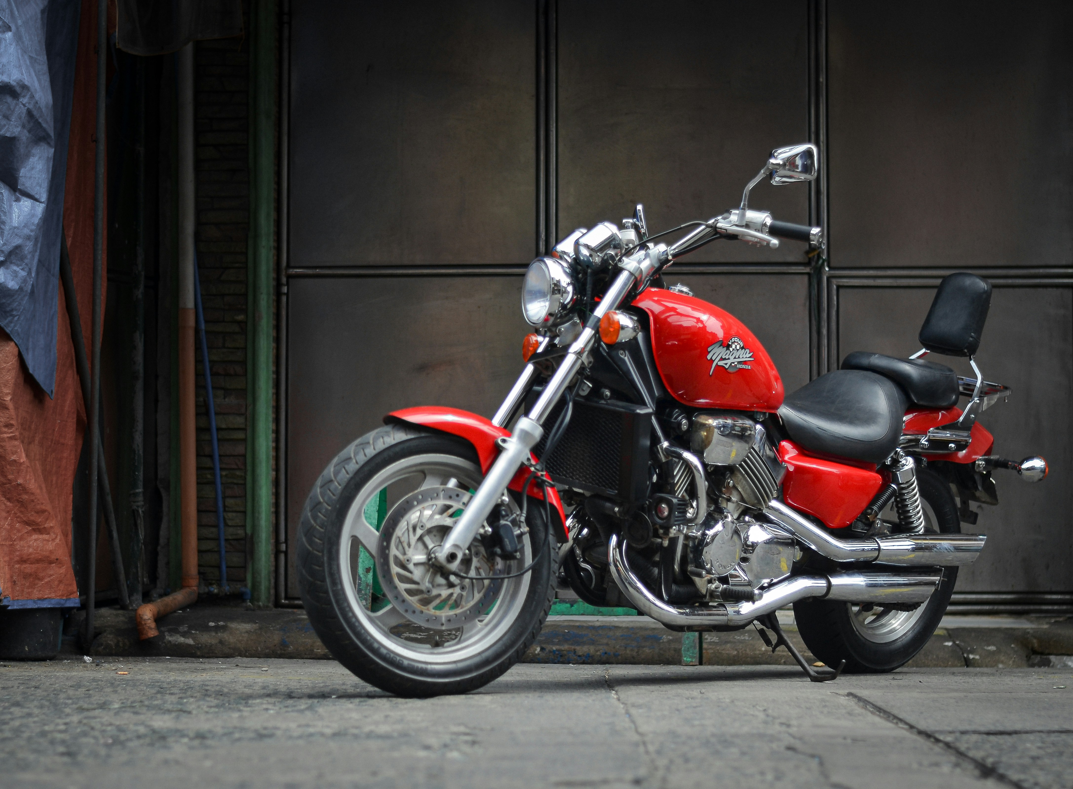 A red motorcycle parked in front of a building