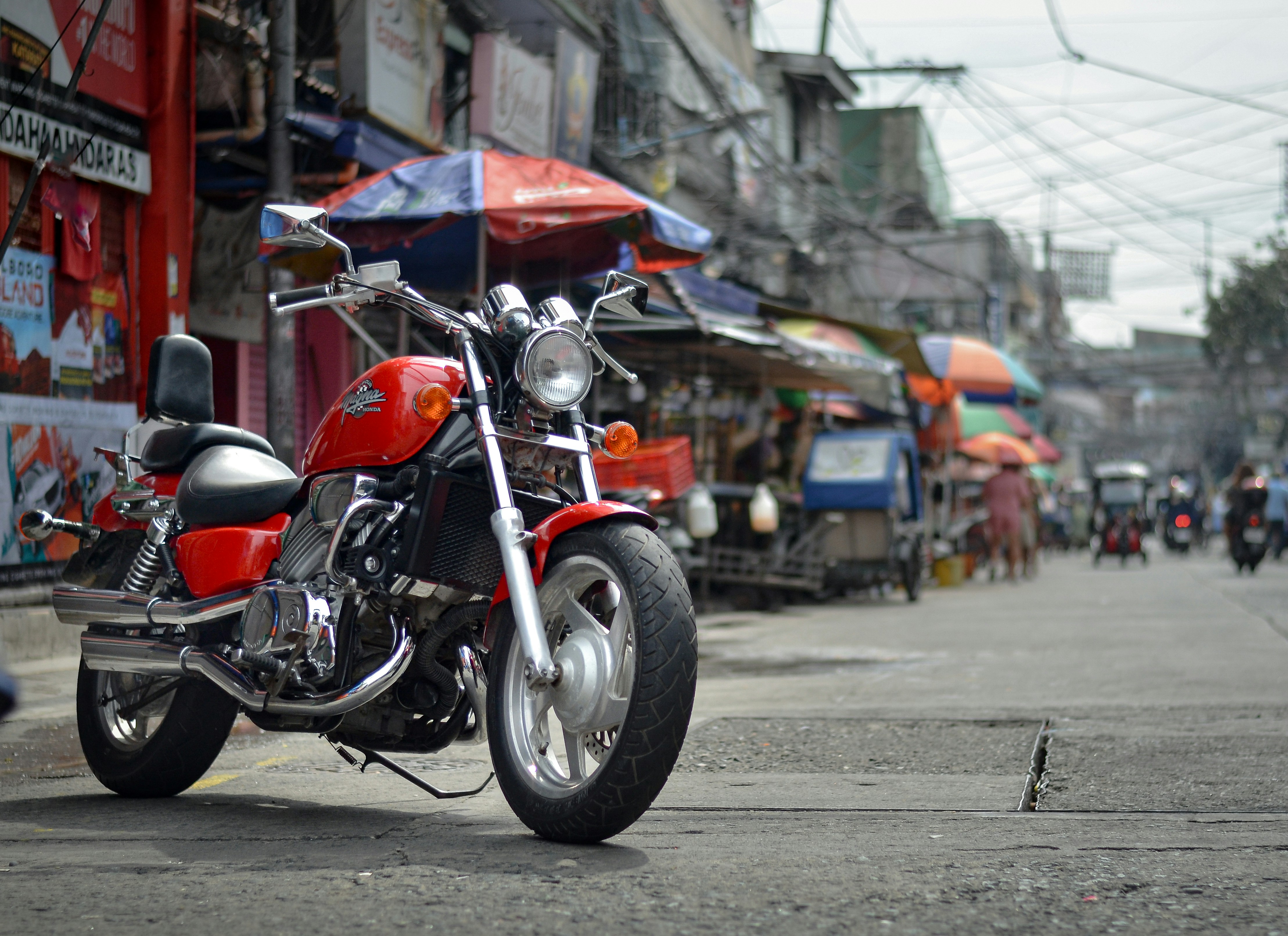 A red motorcycle parked on the side of a street