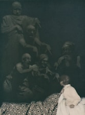 A woman sitting on a bed next to a statue