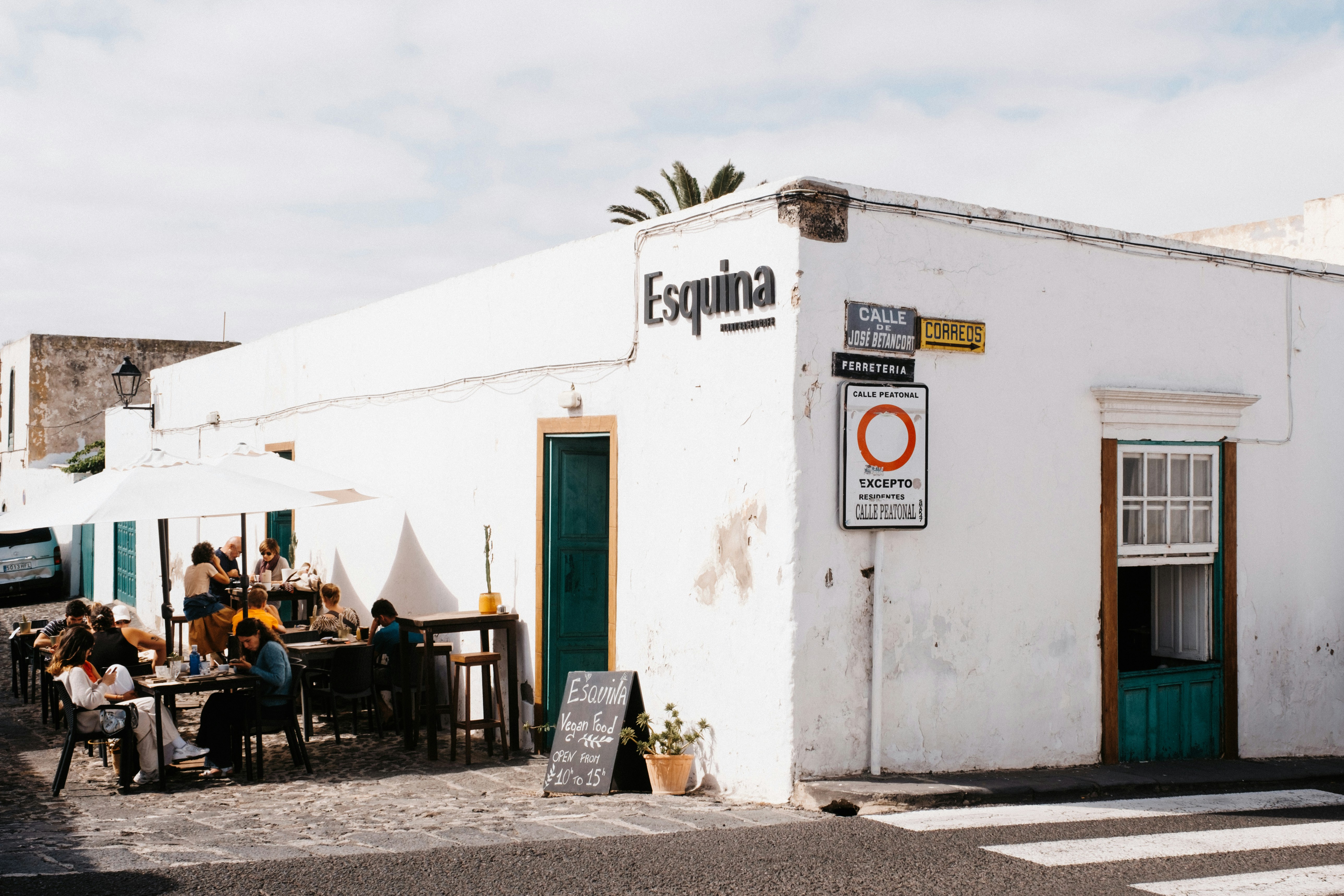 A group of people sitting outside of a white building