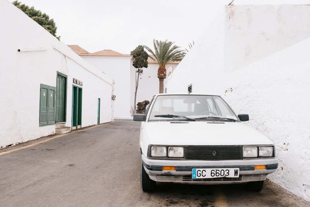 A white car parked on the side of a road,