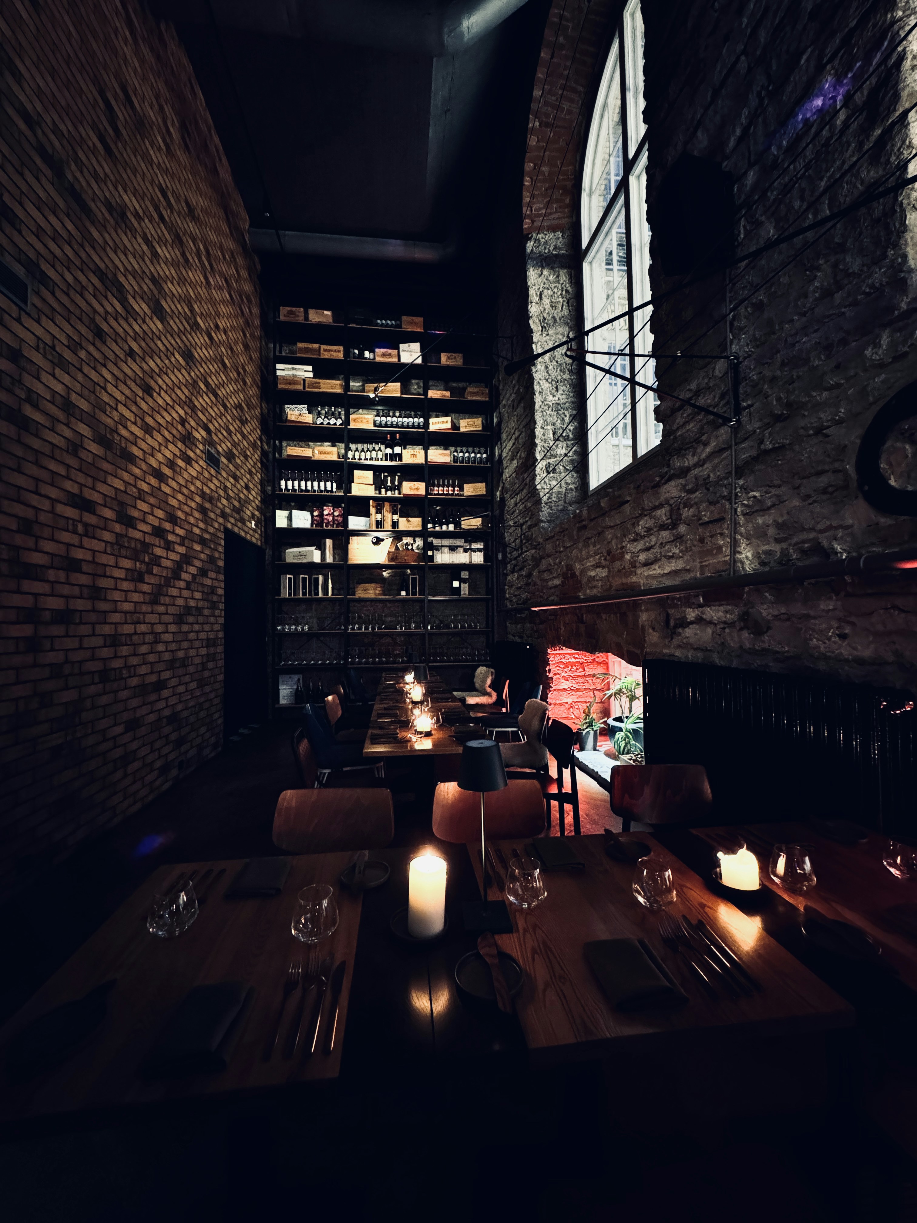 Cozy restaurant corner with brick wall, intimate table for two, and flickering candles