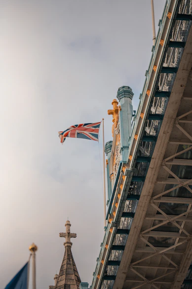 A british flag flying in the air next to a bridge