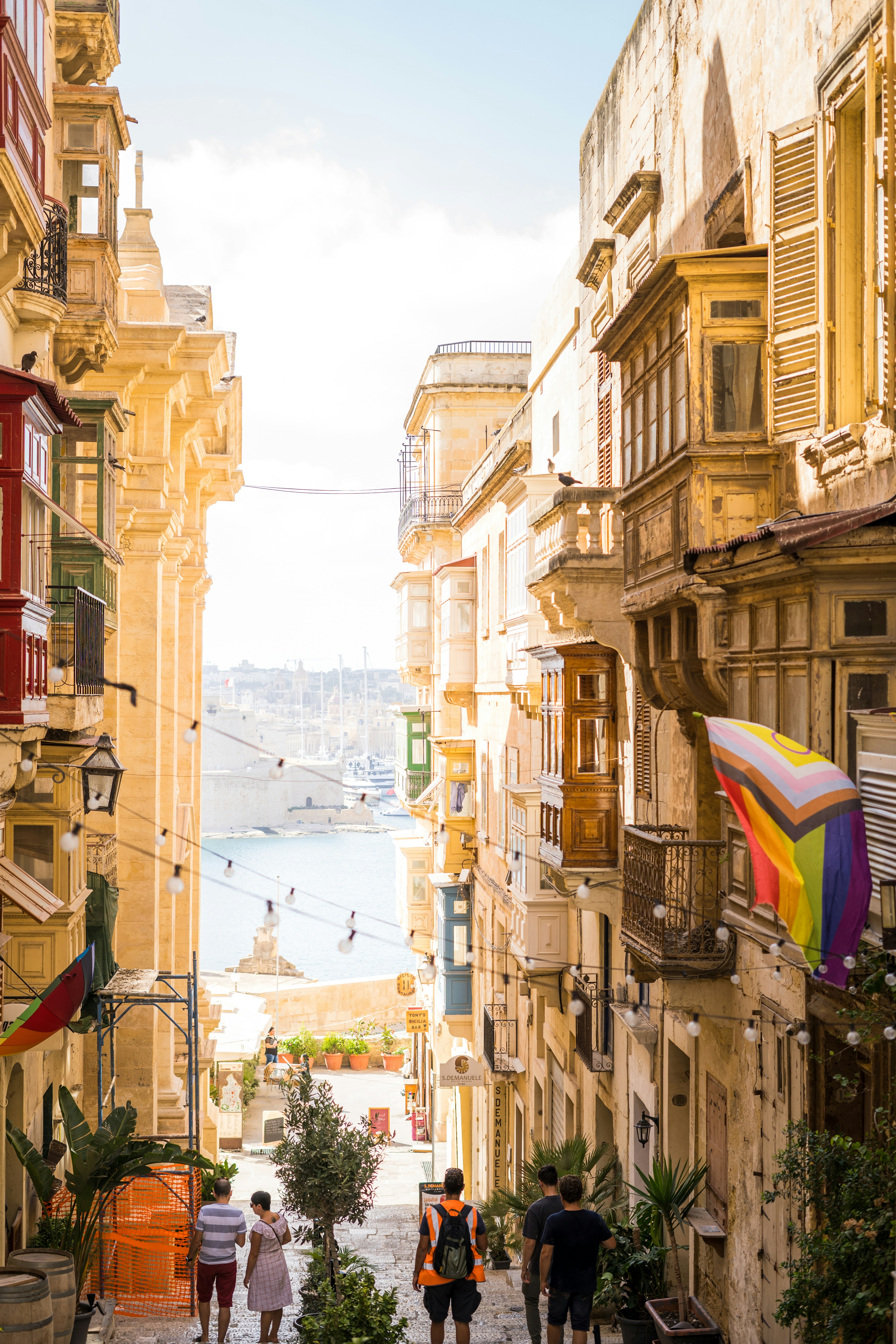 A group of people walking down a street next to tall buildings