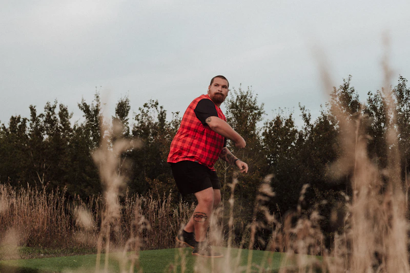 active single man playing frisbee in a field