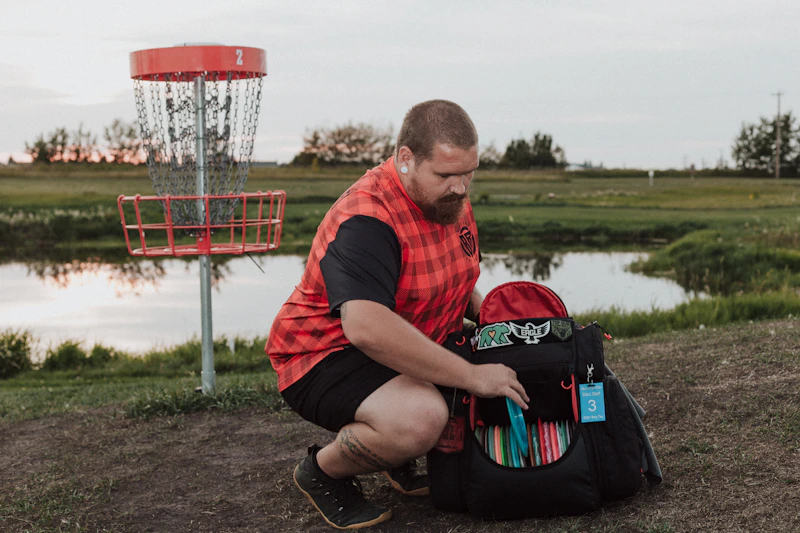 relaxed man sitting in a field beside a frisbee