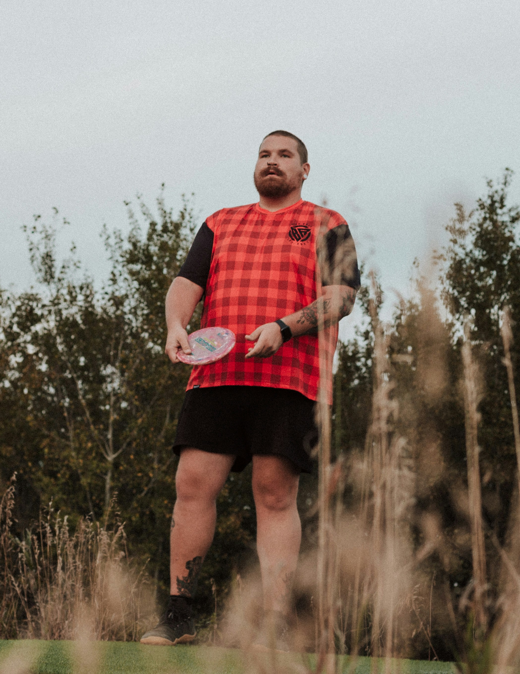 A man standing in a field holding a frisbee