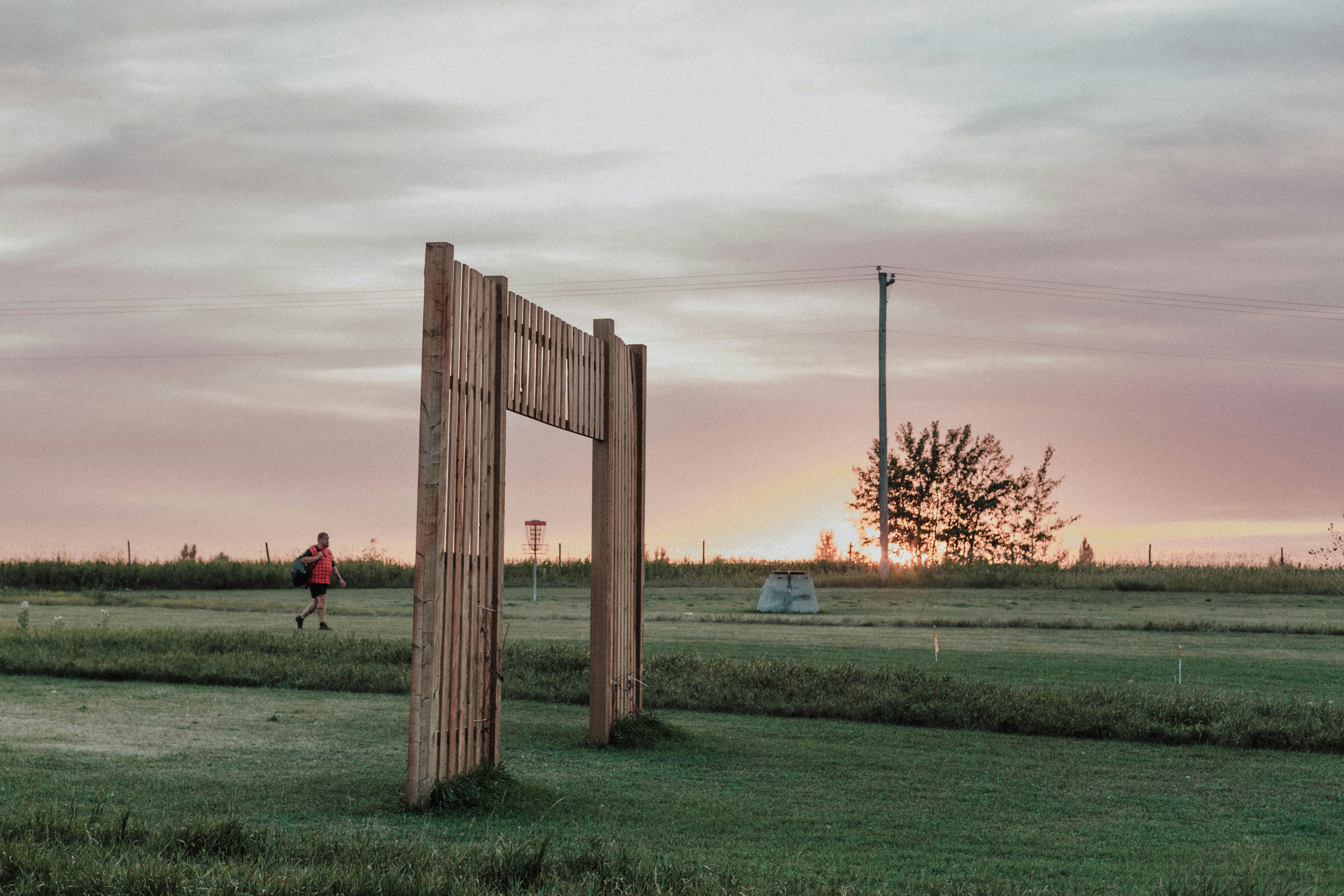 A wooden sign sitting in the middle of a lush green field