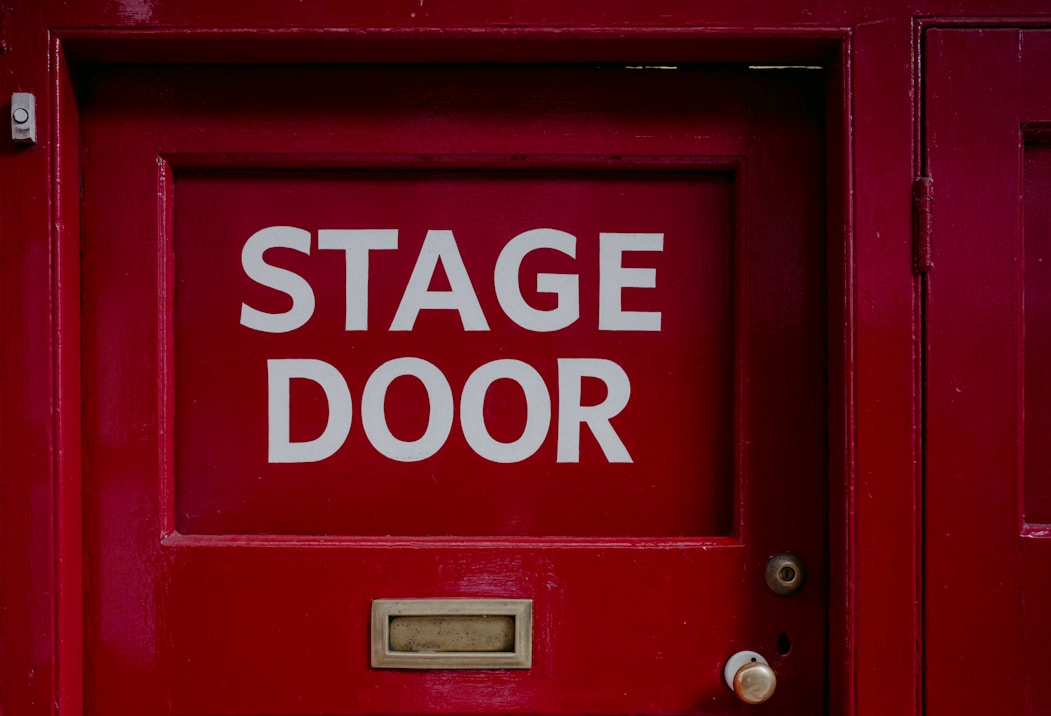 A red door with a sign that says stage door