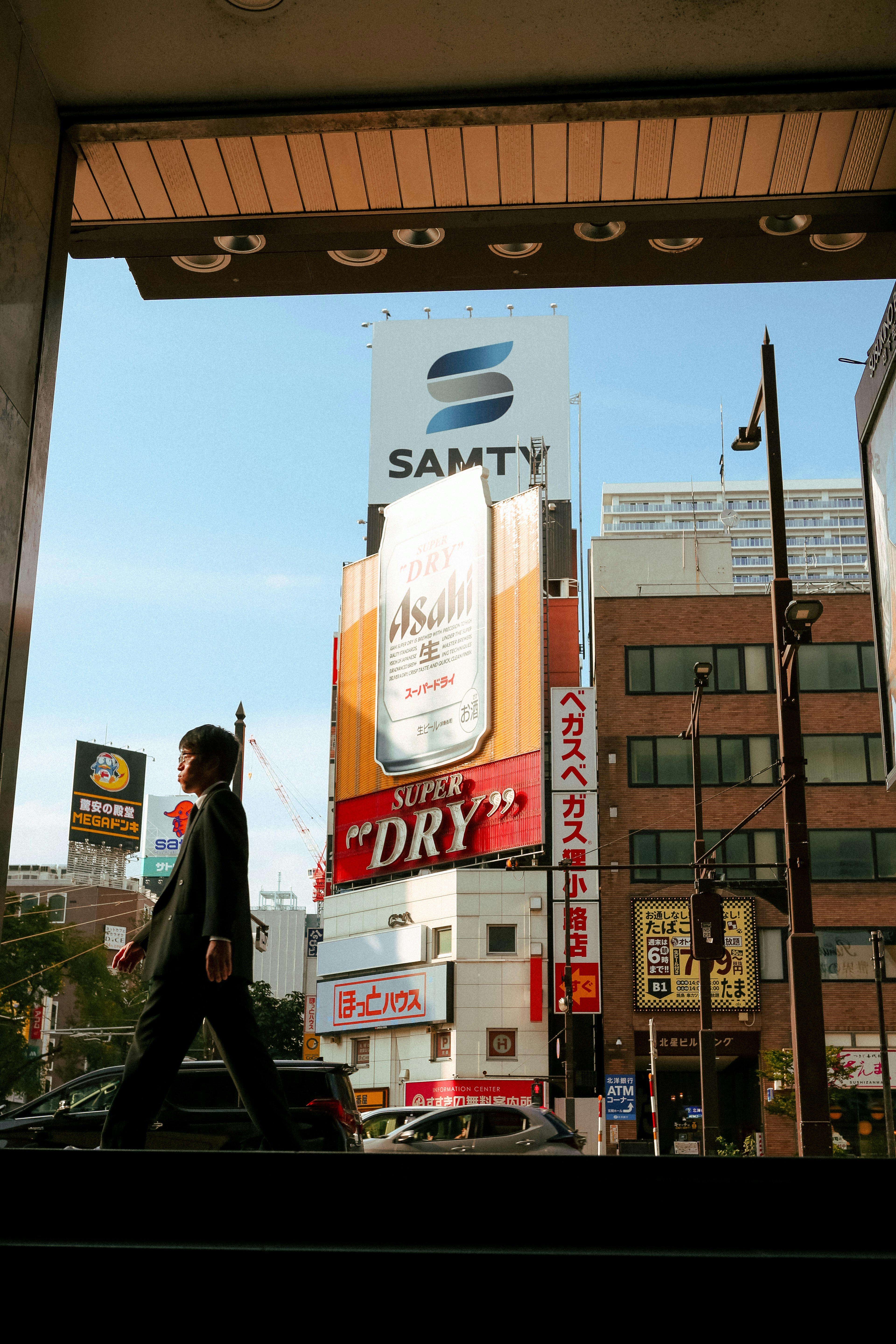 A man walking down a street next to tall buildings