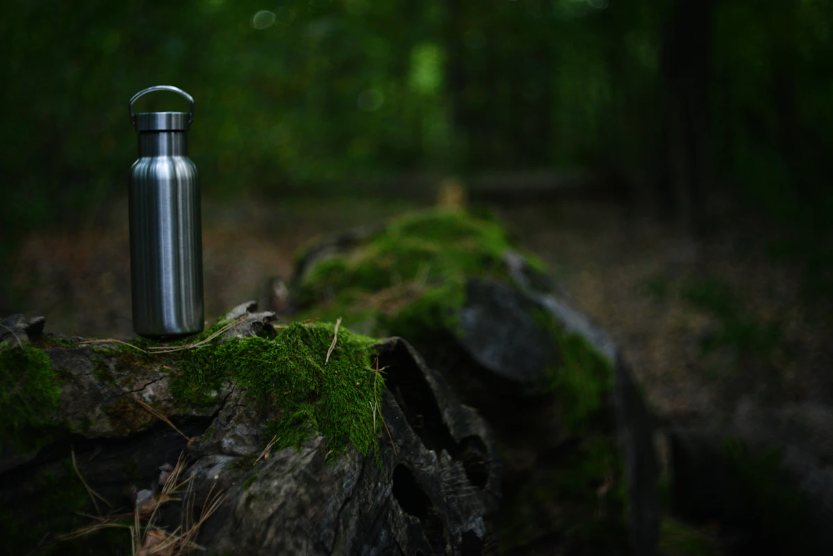 Insulated stainless steel bottle outdoors on a tree stump