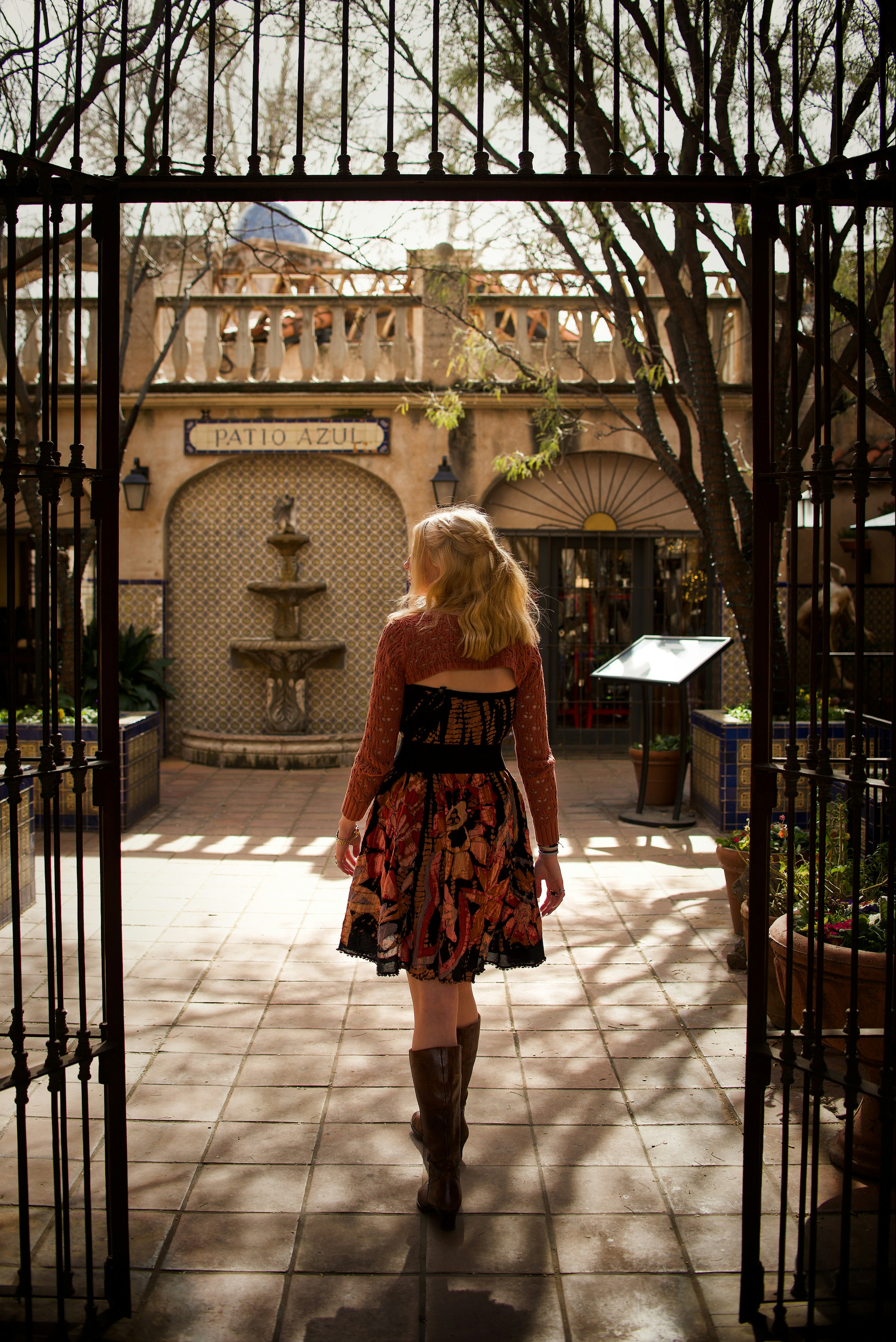 A woman in a dress walking through a gate