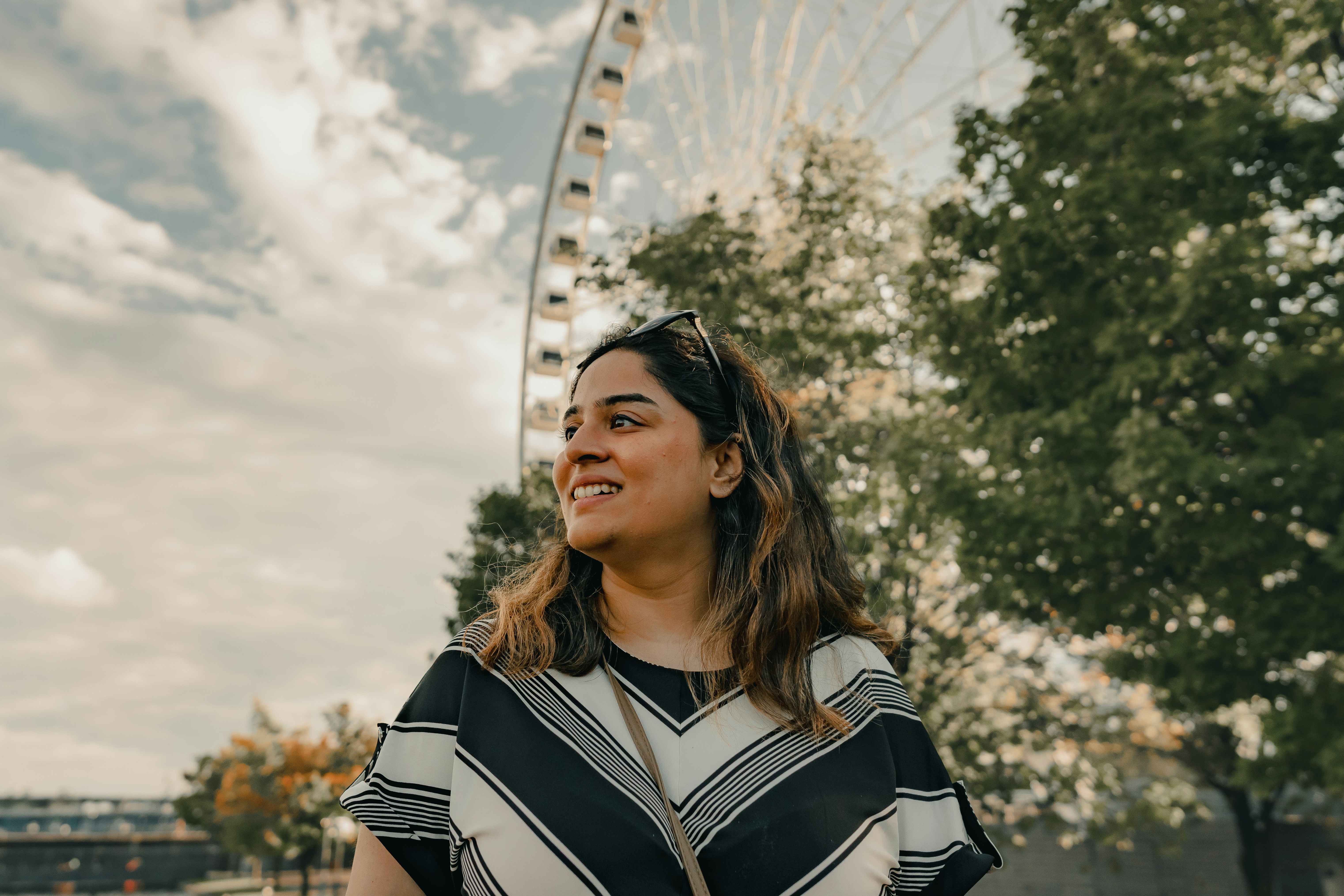 A woman standing in front of a ferris wheel
