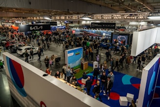 A crowd of people standing around a car show