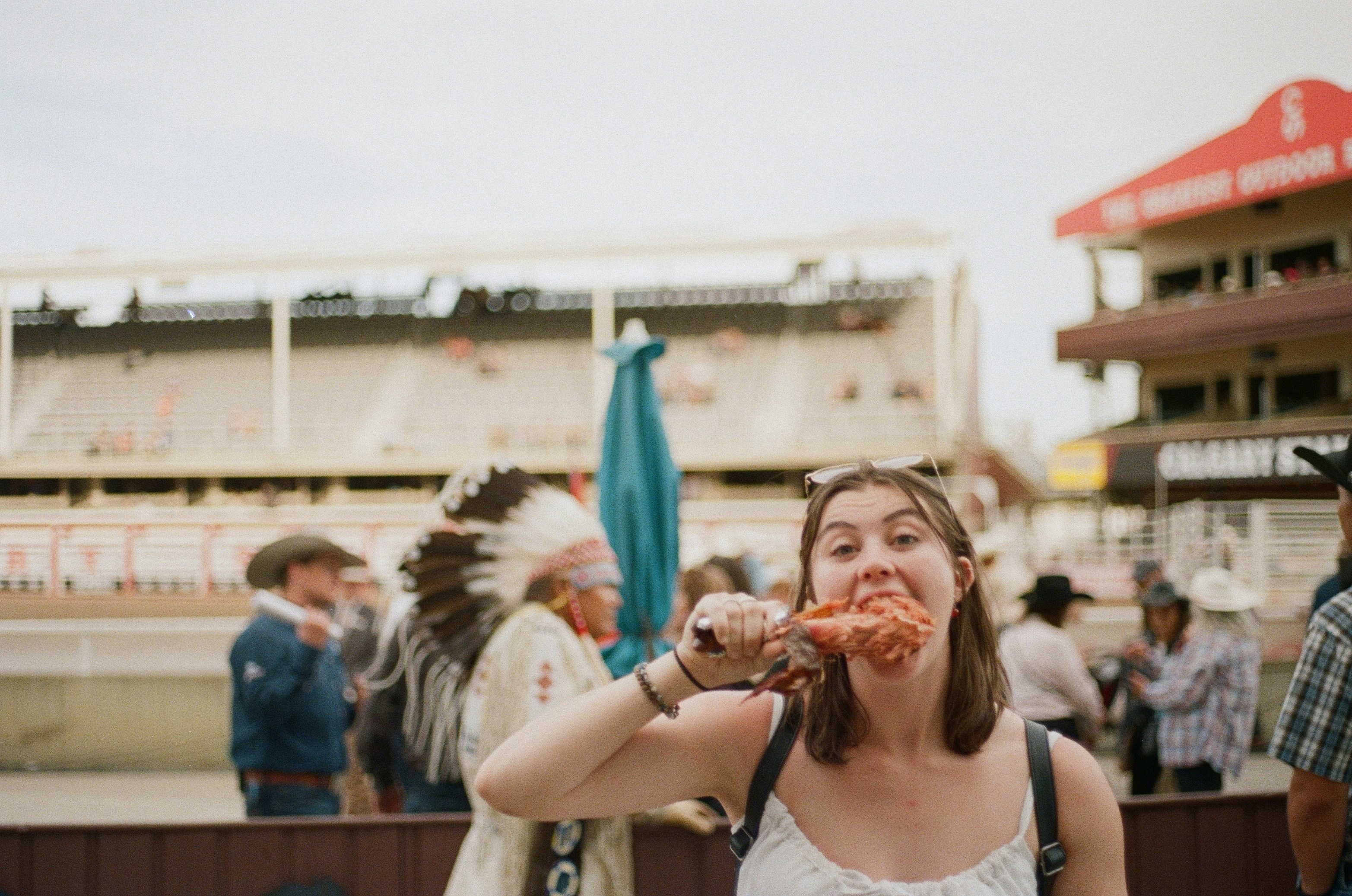 A woman eating a donut in front of a crowd of people