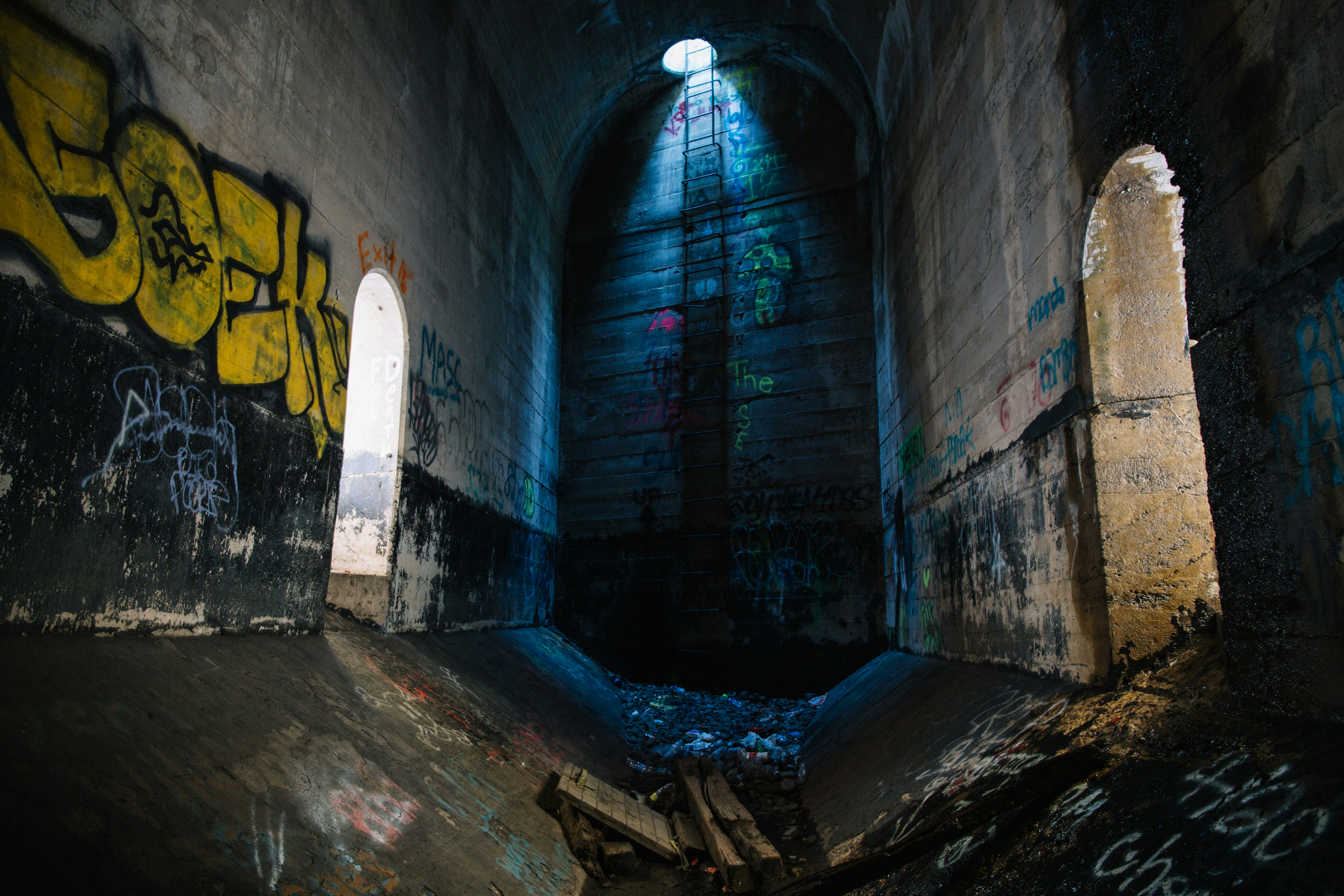 A dark tunnel with graffiti on the walls