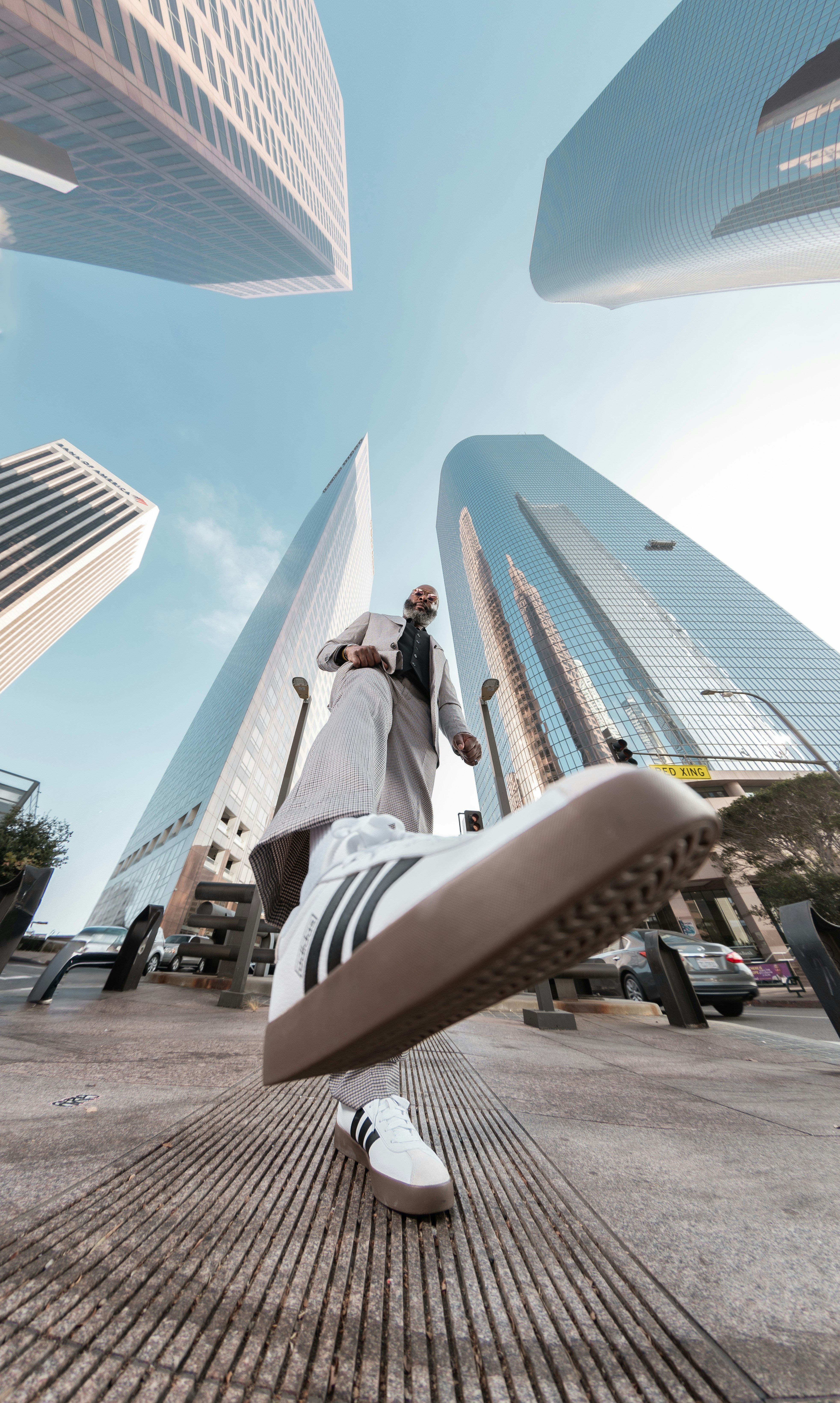 A man walking through a city with tall buildings