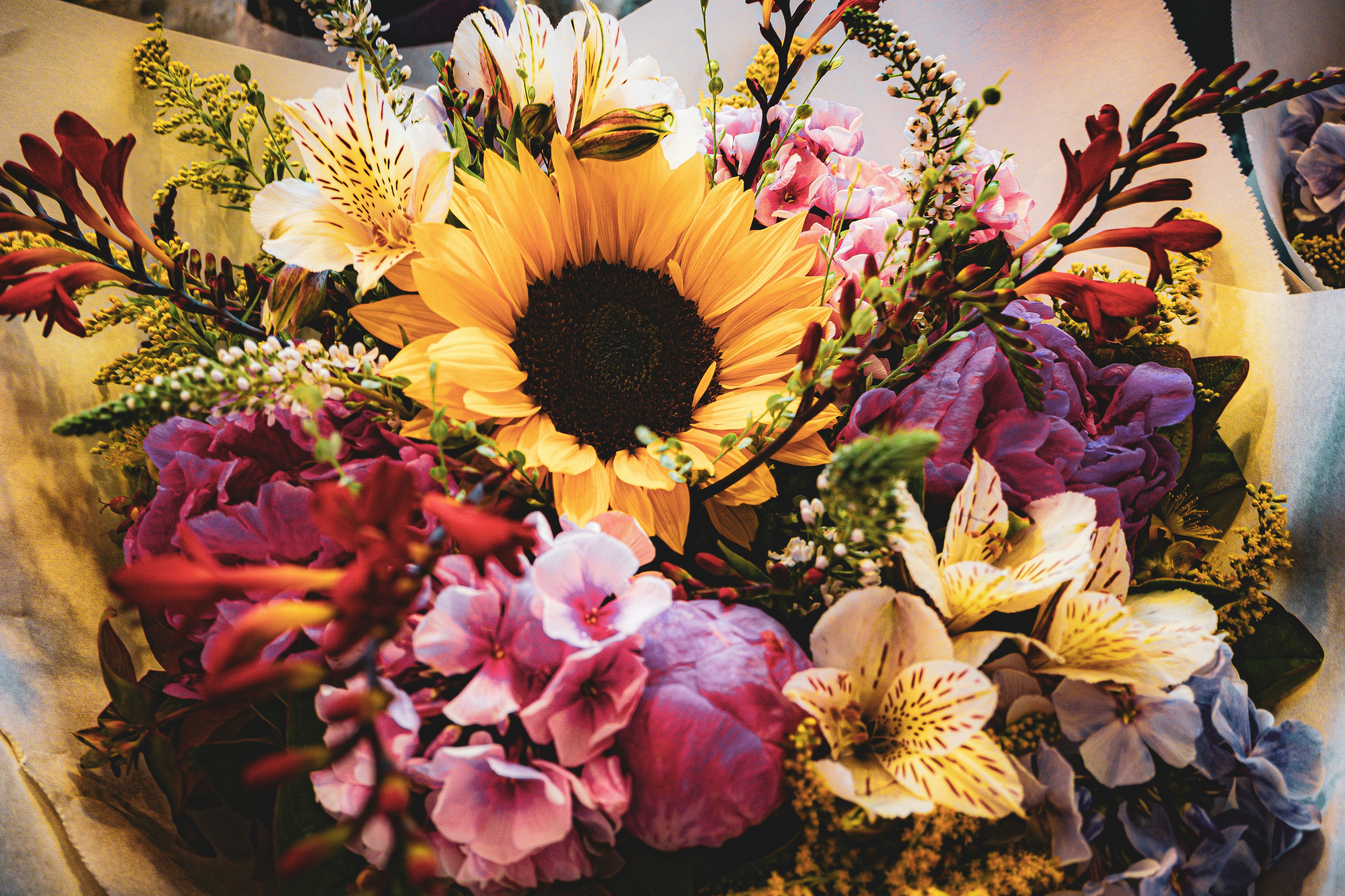 Colorful mixed flower arrangement with sunflowers and lilies for celebration event