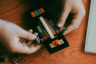 A person is playing with legos on a table