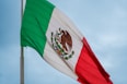 The mexican flag is flying high in the sky