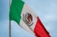 The mexican flag is flying high in the sky