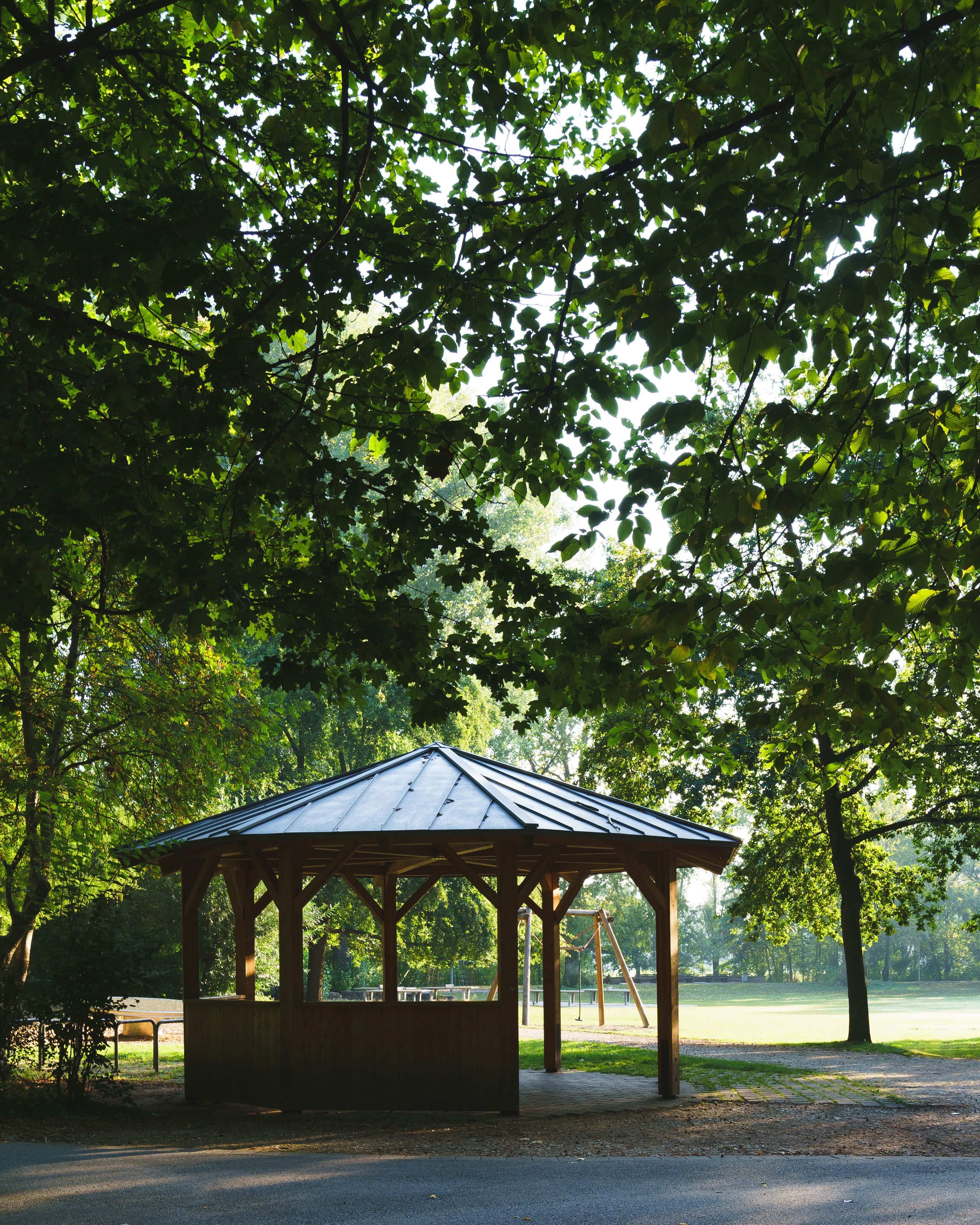 A gazebo in the middle of a park surrounded by trees