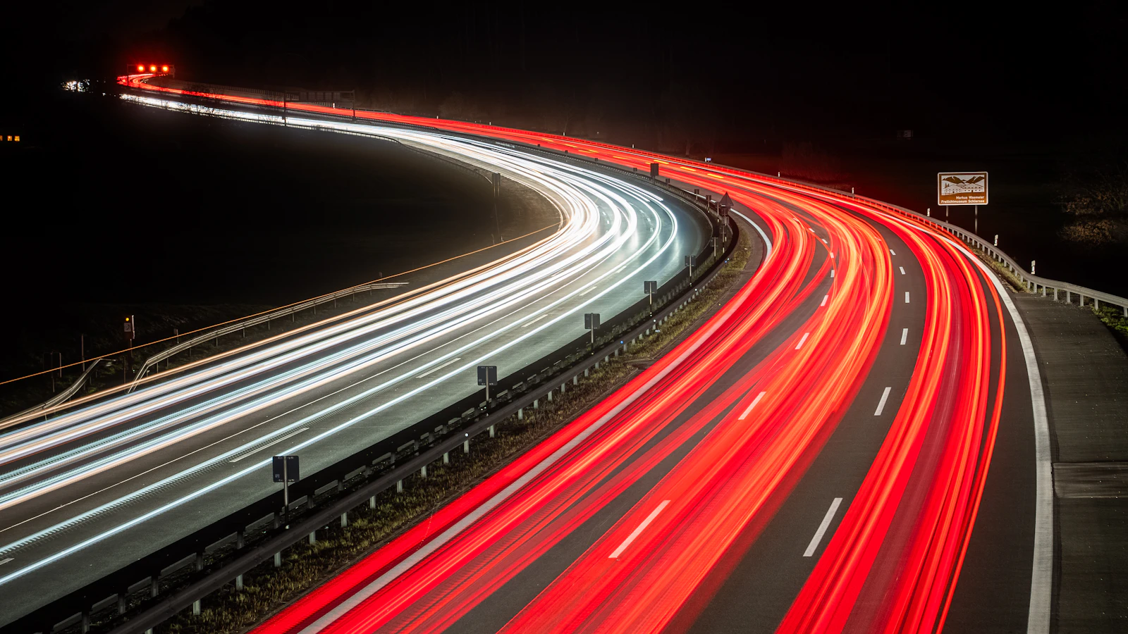 Autopista de noche con estelas de luz de los vehículos en larga exposición