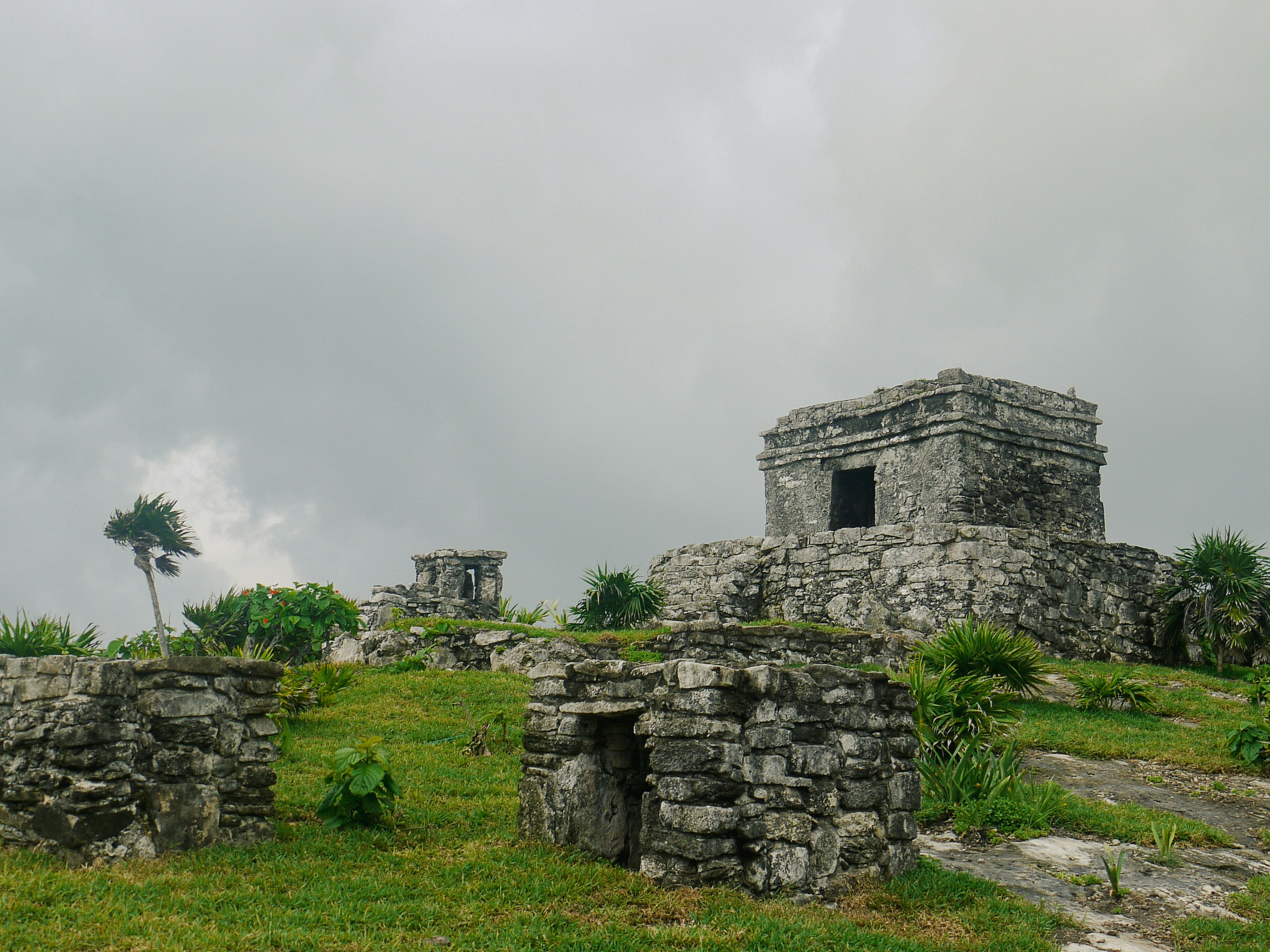 A stone structure sitting on top of a lush green field