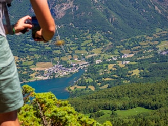 A man standing on top of a lush green hillside