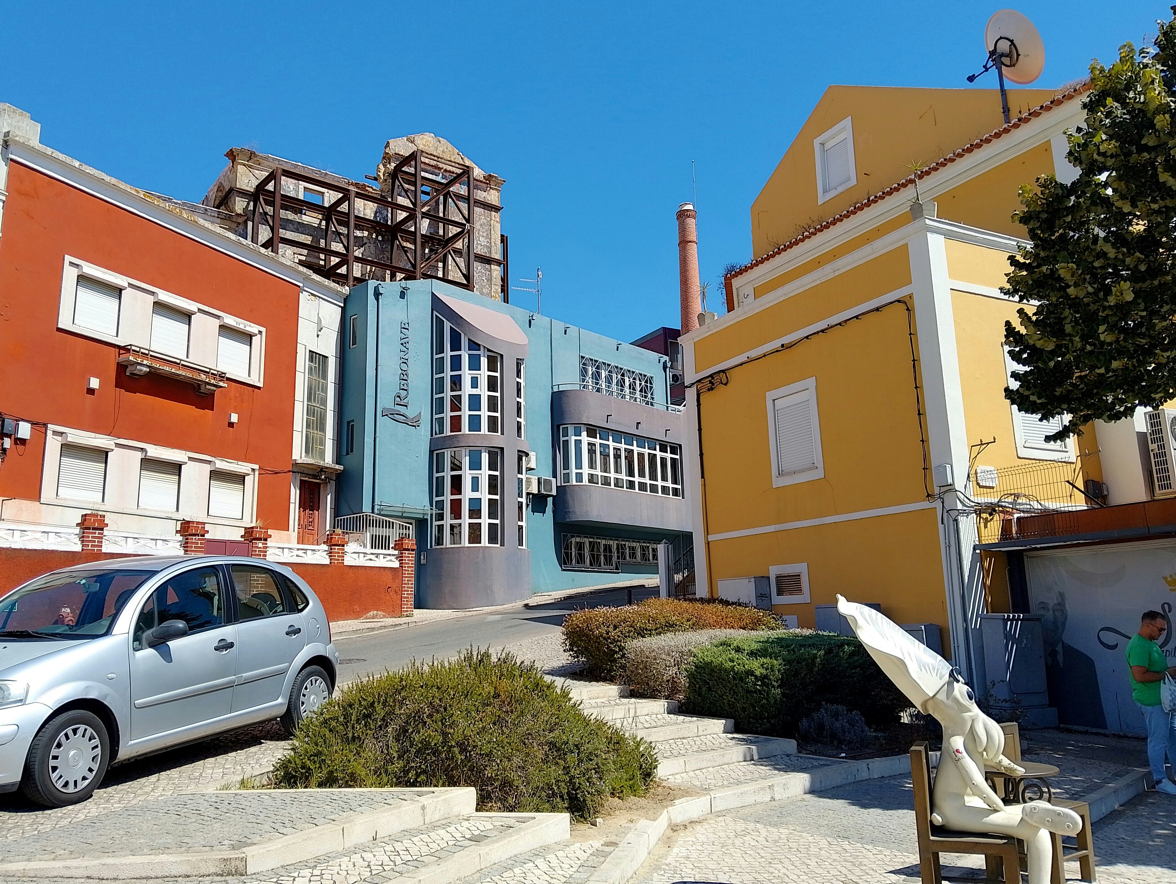 A car parked on the side of a road next to a building