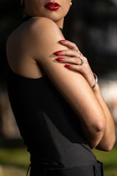 A woman in a black dress with her arms crossed