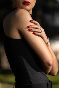 A woman in a black dress with her arms crossed