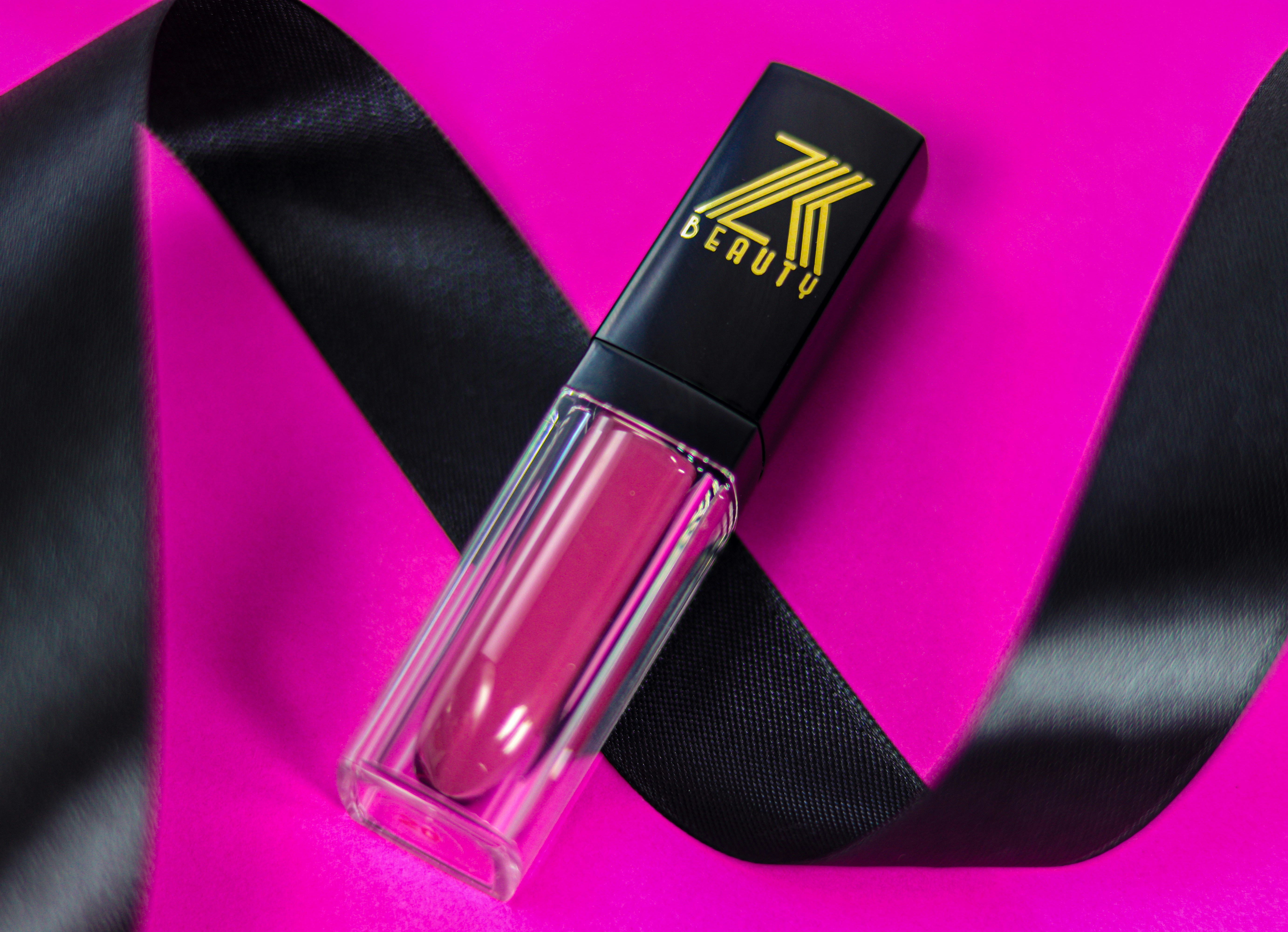 A close up of a lipstick on a pink background