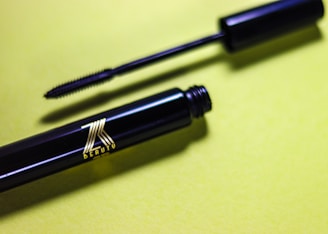 A pair of black pens sitting on top of a table