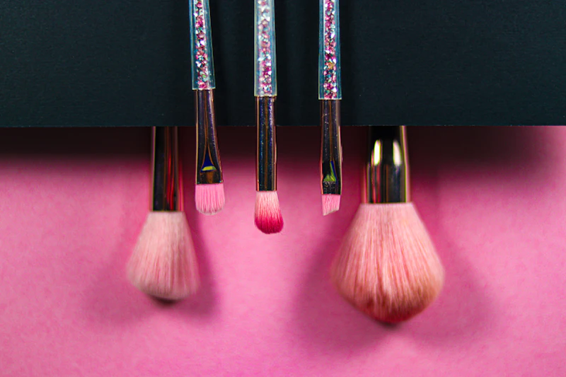 Pinceaux de maquillage sur fond rose